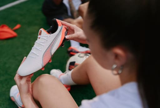 Eine Frau haelt einen Puma Untamed Fussballschuh.