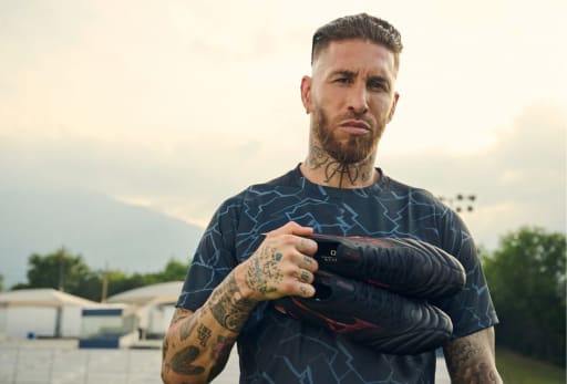Sergio Ramos haelt einen Mizuno Shadow Gem Fussballschuh.