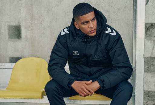 Ein Fussballspieler sitzt auf der Bank.