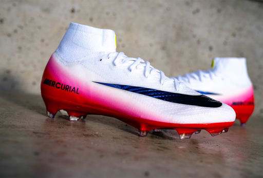 Ein paar weisse Nike Fear Nothing Fussbalsschuhe mit roten Akzenten.