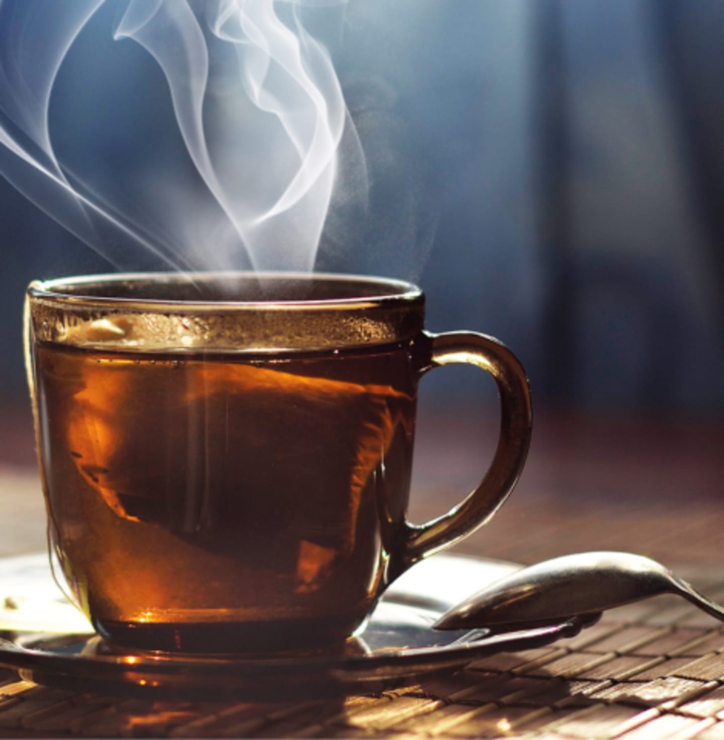 Herbata gorąca na stole, z której unosi się para wodna.