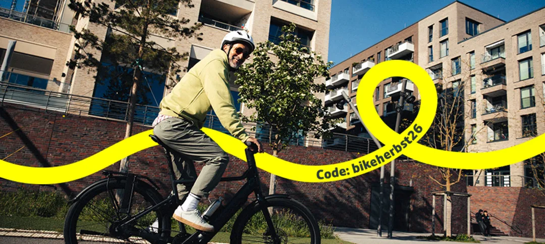Ein älterer Mann fährt auf einem City E-Bike durch eine Stadt