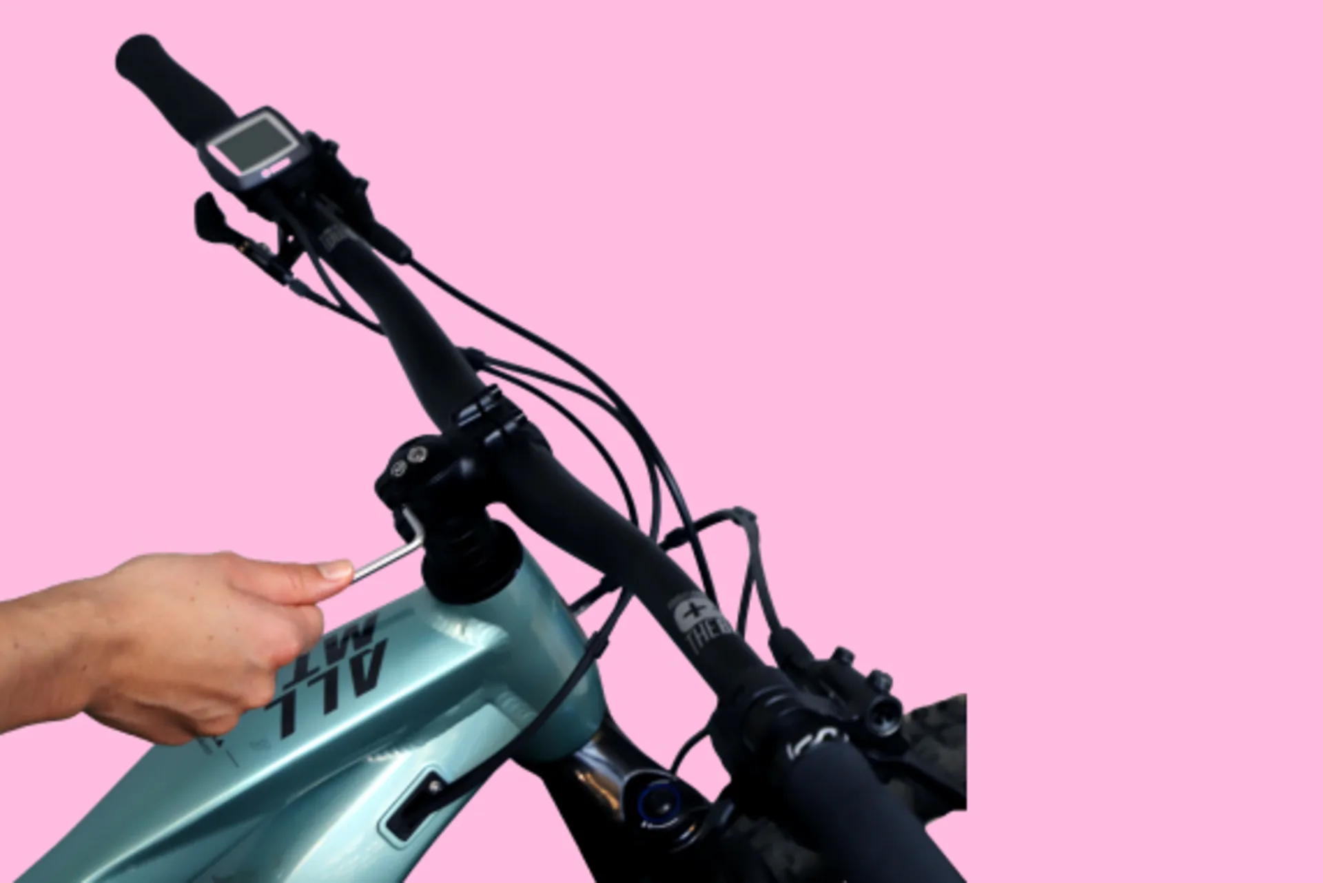 Eine Hand zieht die Klemmschrauben am Lenker eines Mountainbikes fest