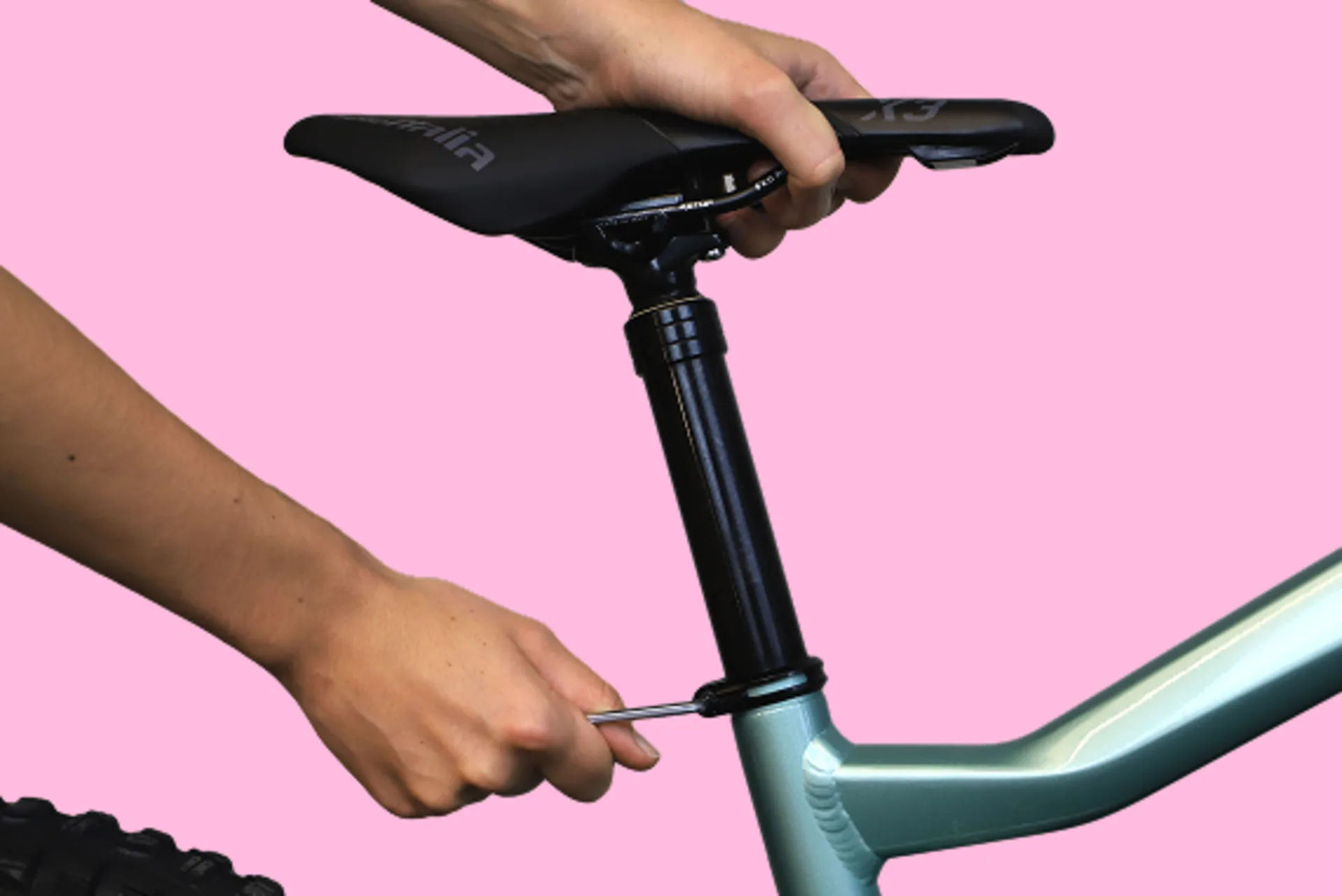 Eine Hand öffnet die Klemmschraube eines Fahrradsattels