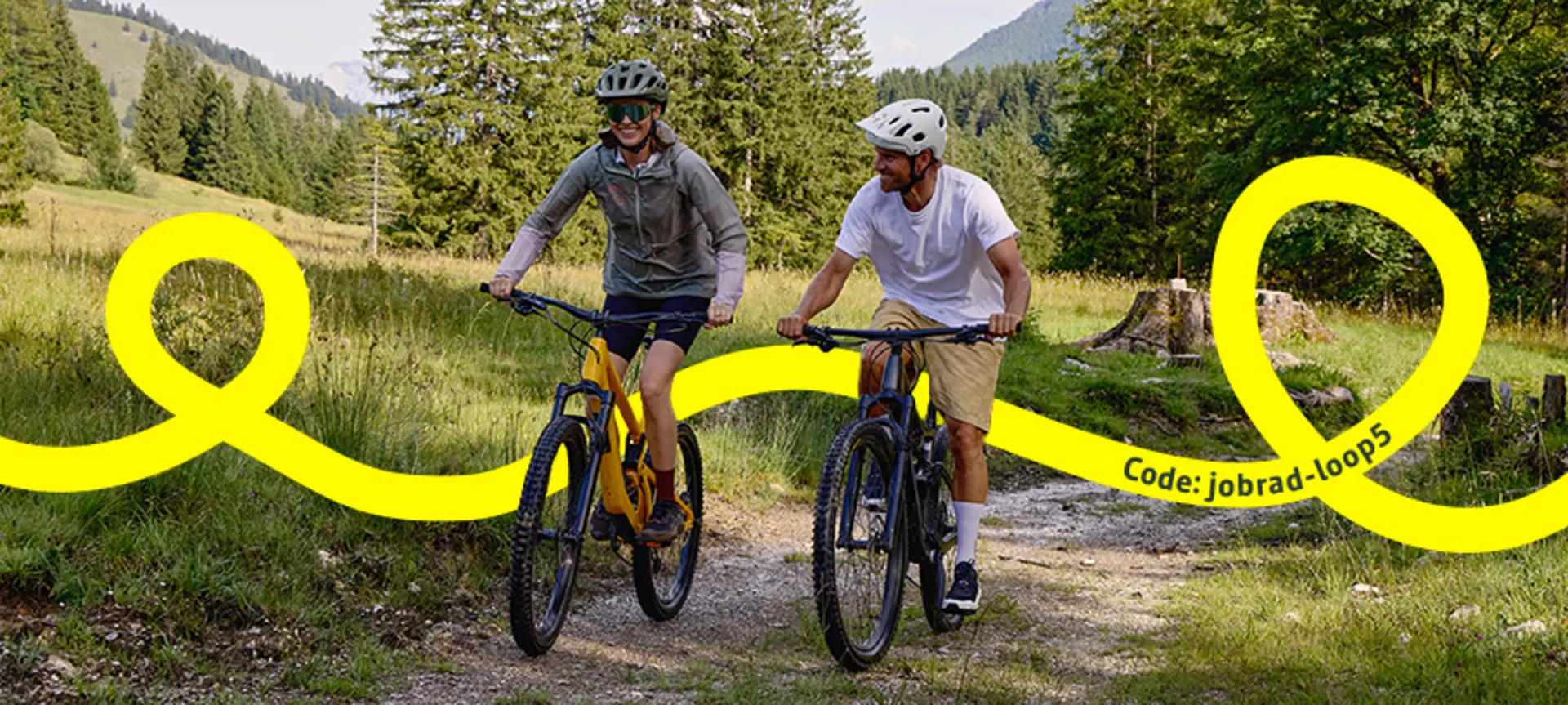 Mann trägt ein Gravelbike auf einem Berg zu seinem Zelt.