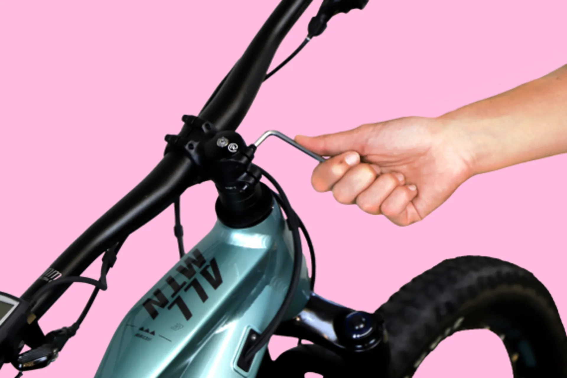 Eine Hand dreht die Schrauben am Lenker eines E-Bikes