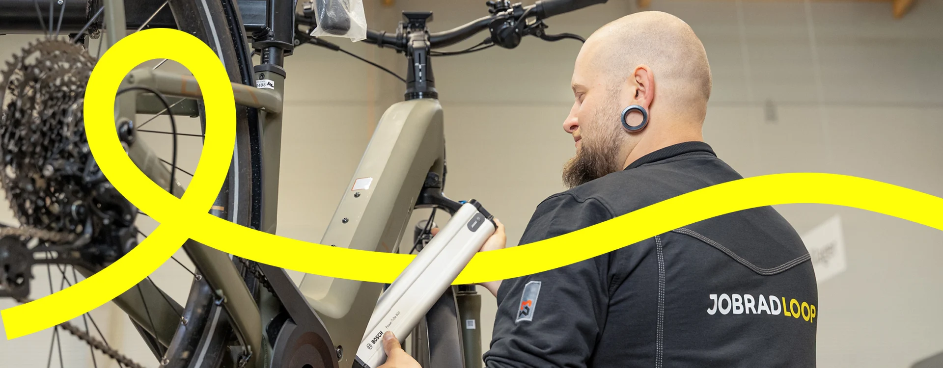Mechaniker wechselt den Akku am E-Bike