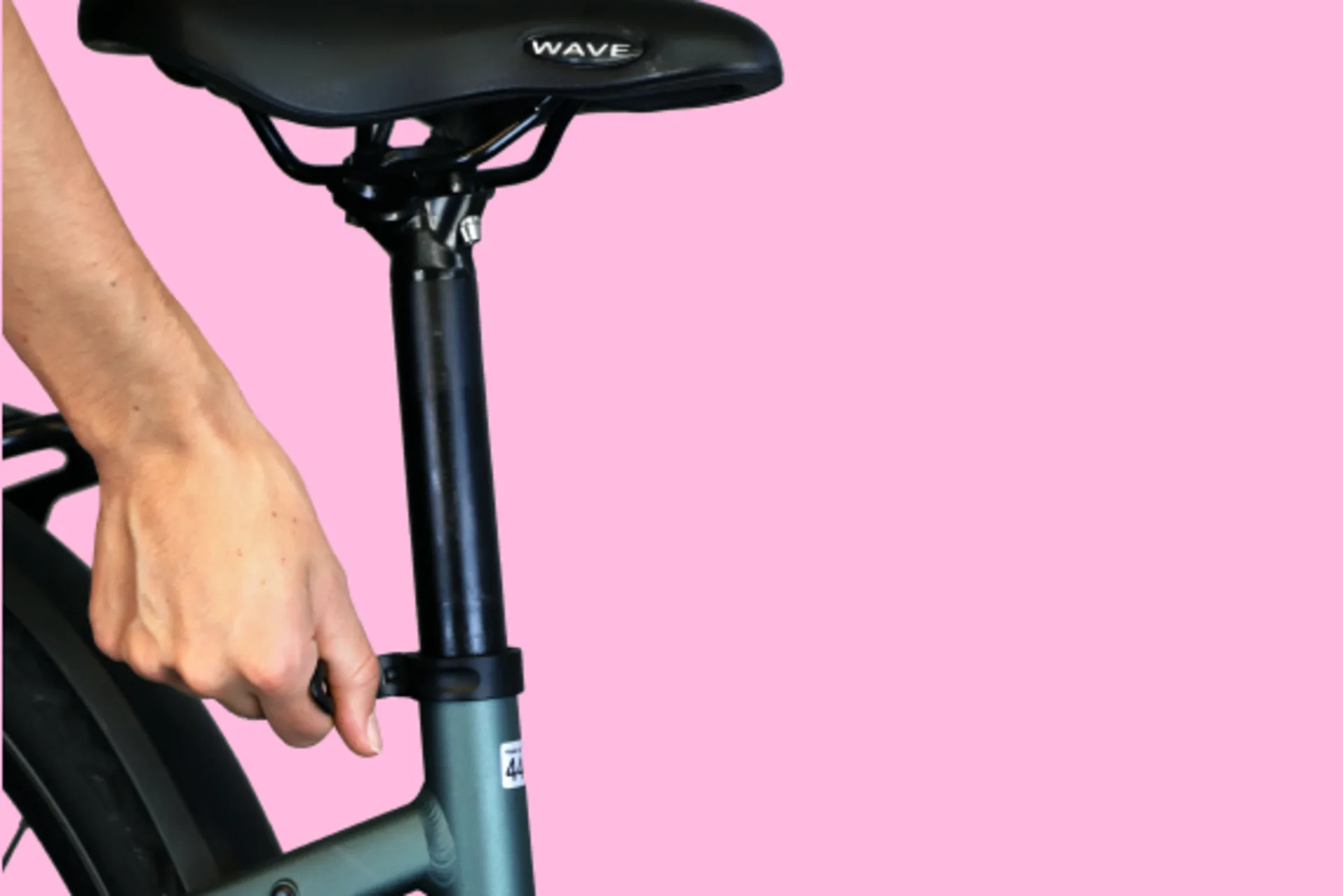 Eine Hand öffnet den Schnellspanner einer Fahrrad Sattelstützenklemmung