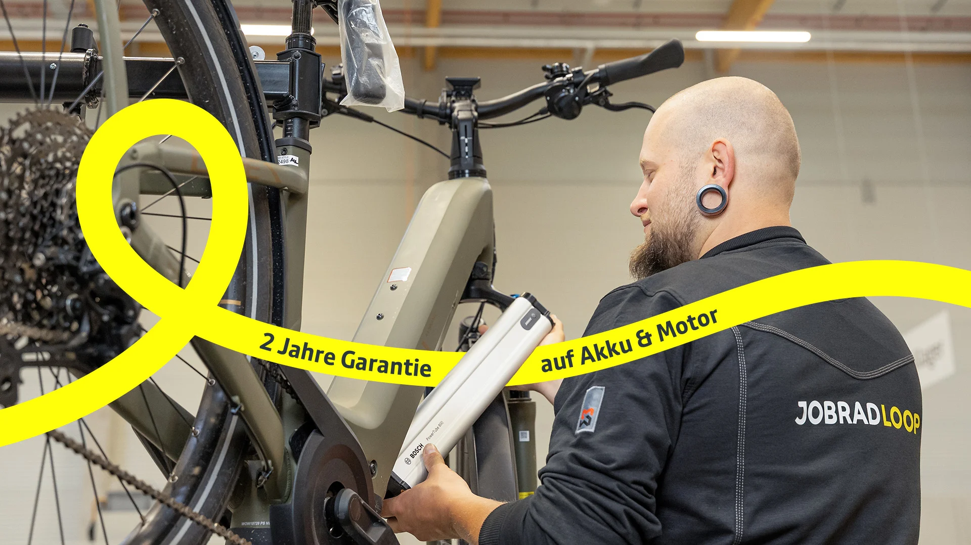 Mechaniker wechselt Akku an E-Bike.