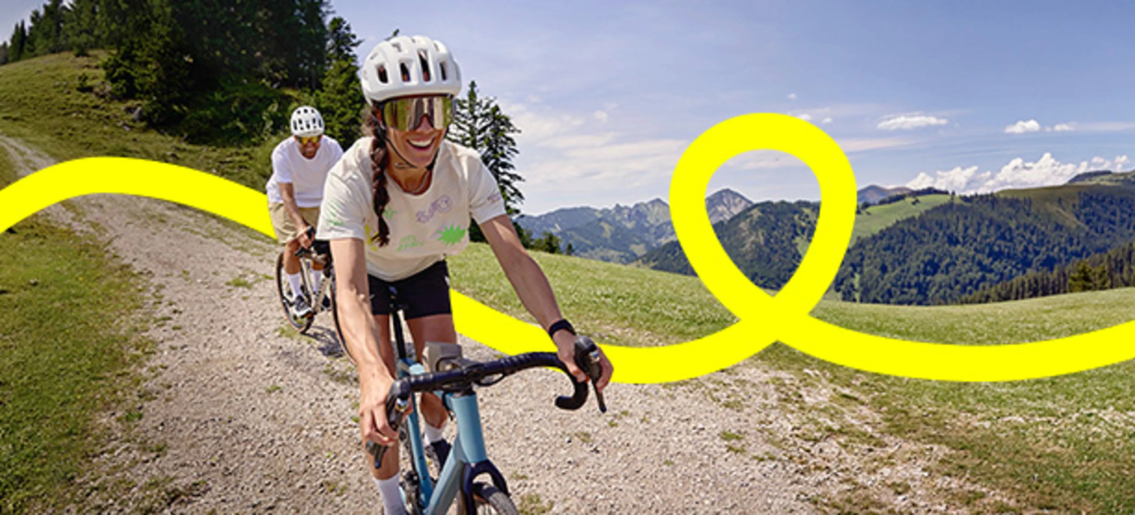 2 Personen fahren mit einem Fahrrad einen Berg runter