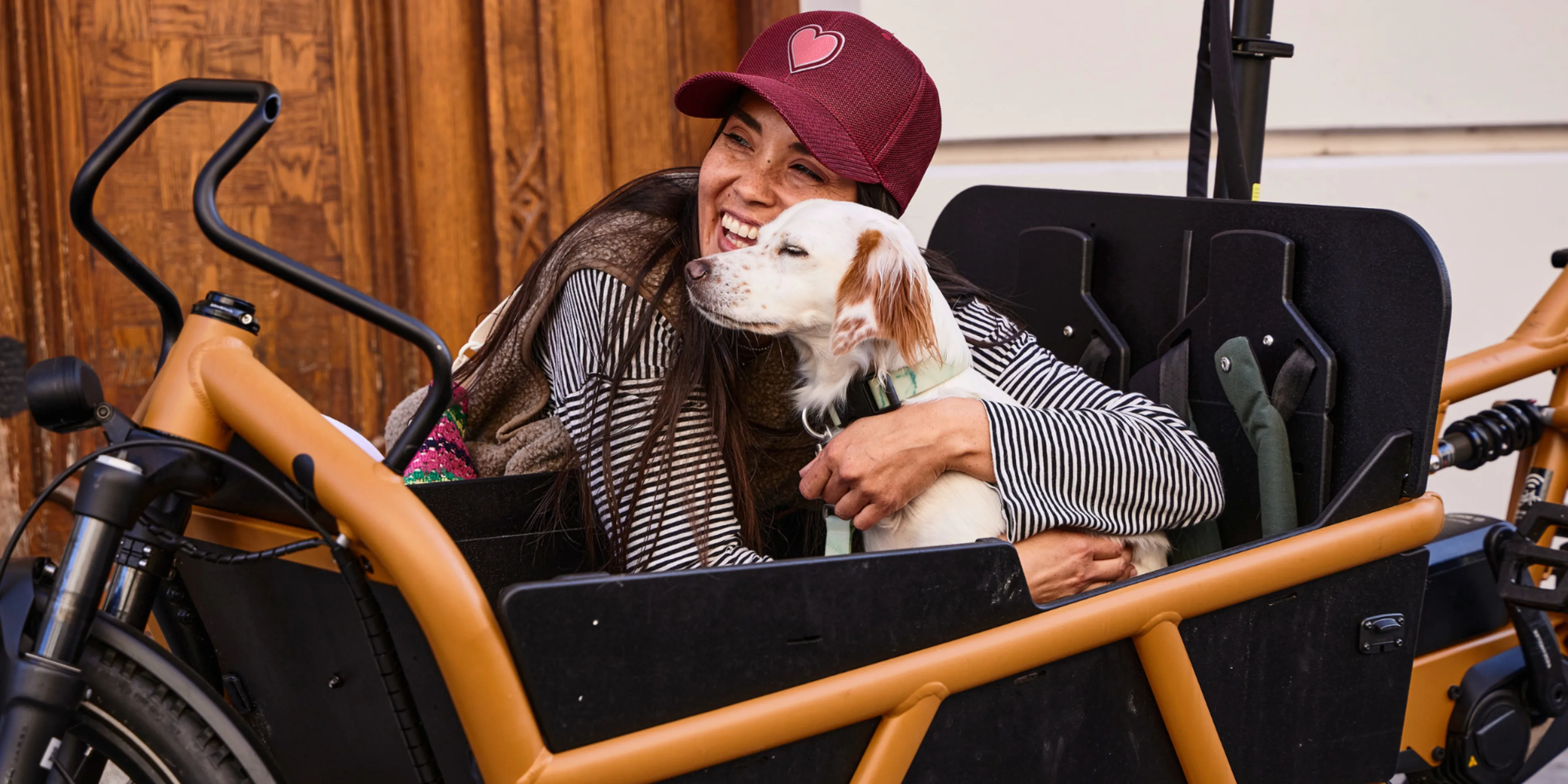 Frau mit Hund im Lastenrad