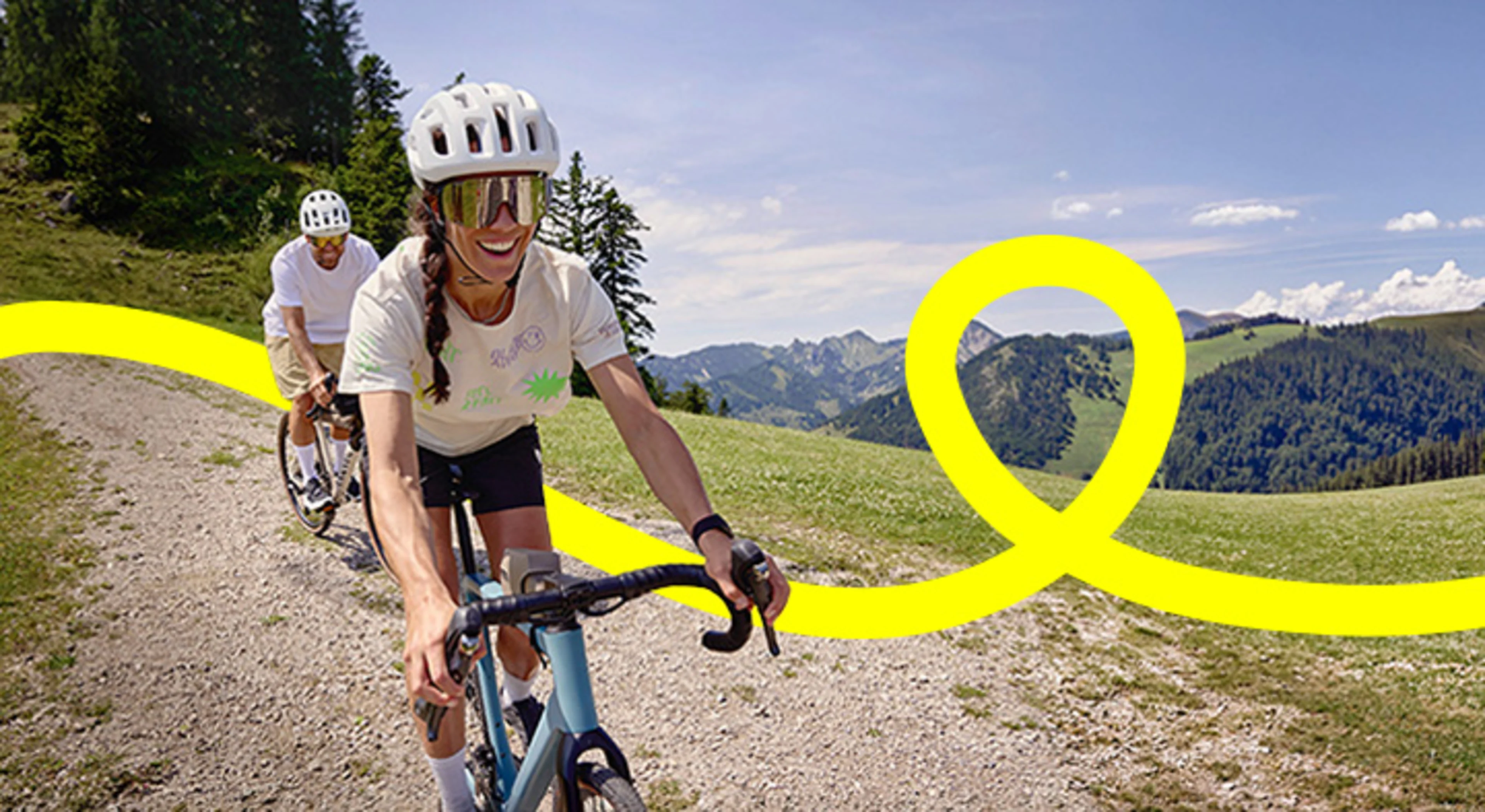 Zwei Menschen fahren mit dem Fahrrad eine Abfahrt in den Bergen 