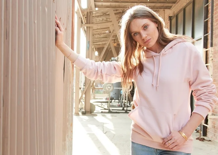 Female model wearing light hooded fleece sweatshirt