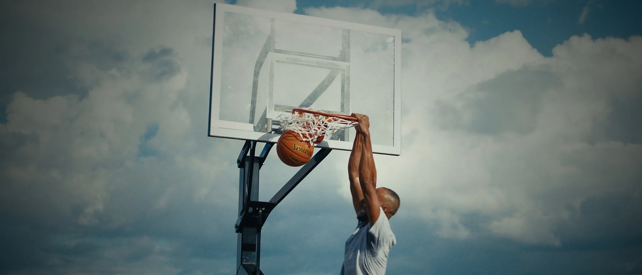 man dunking a basketball on a spalding system