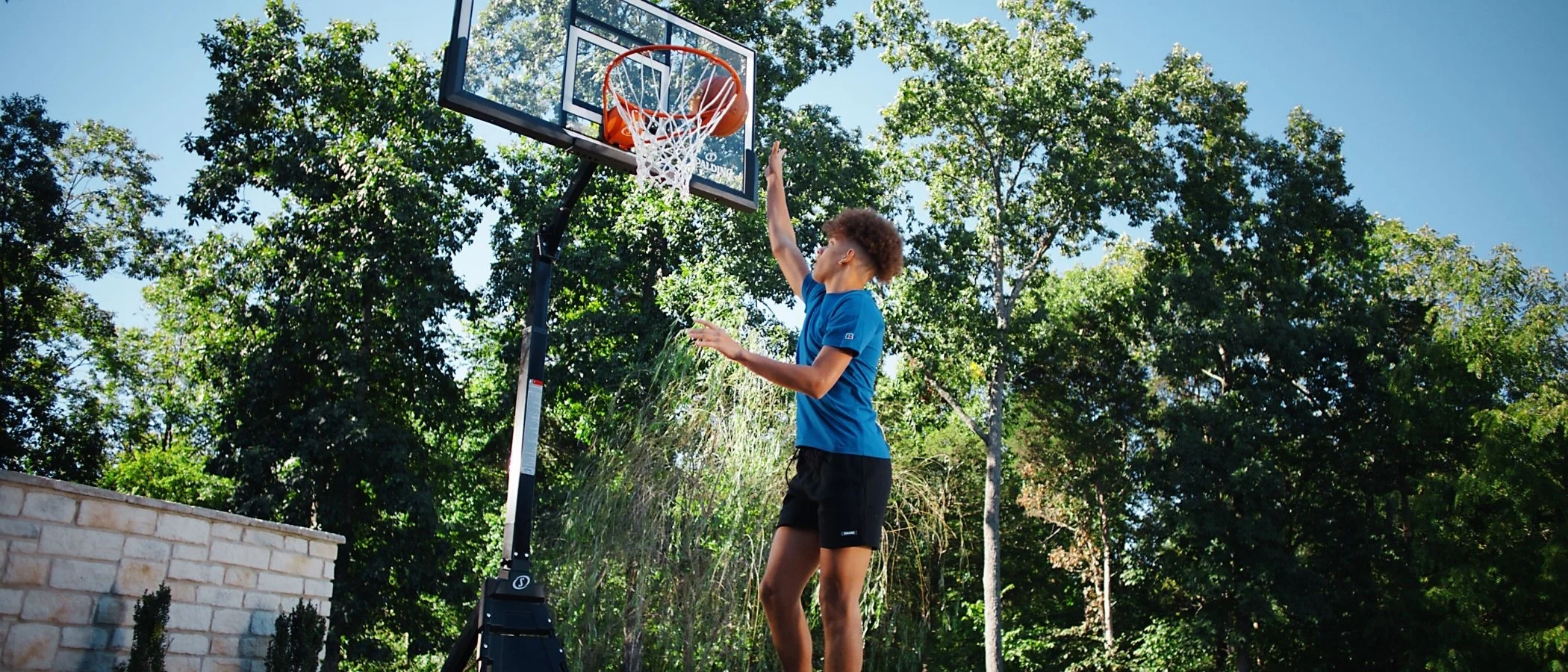 man dunking a basketball on a spalding system