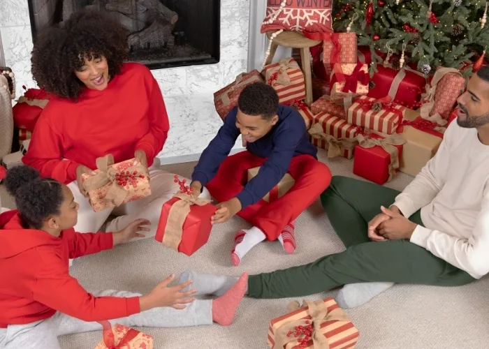 Family exchanging gifts. Focus is on the kids exchanging a gift .