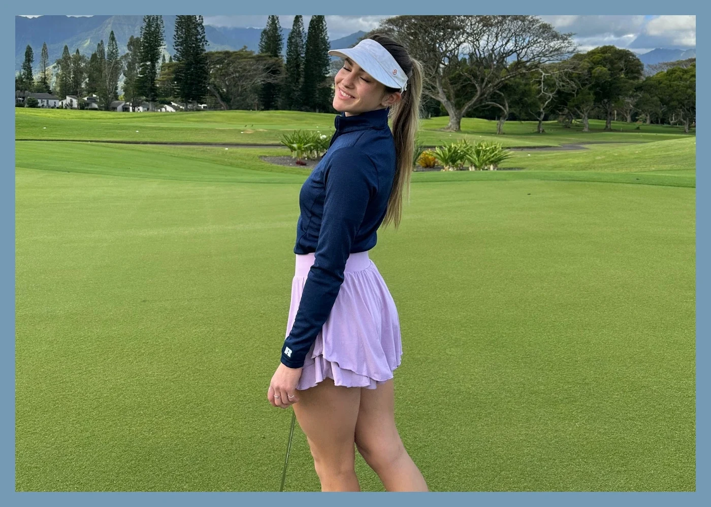 Female model wearing green polo, white skirt, and sunglasses