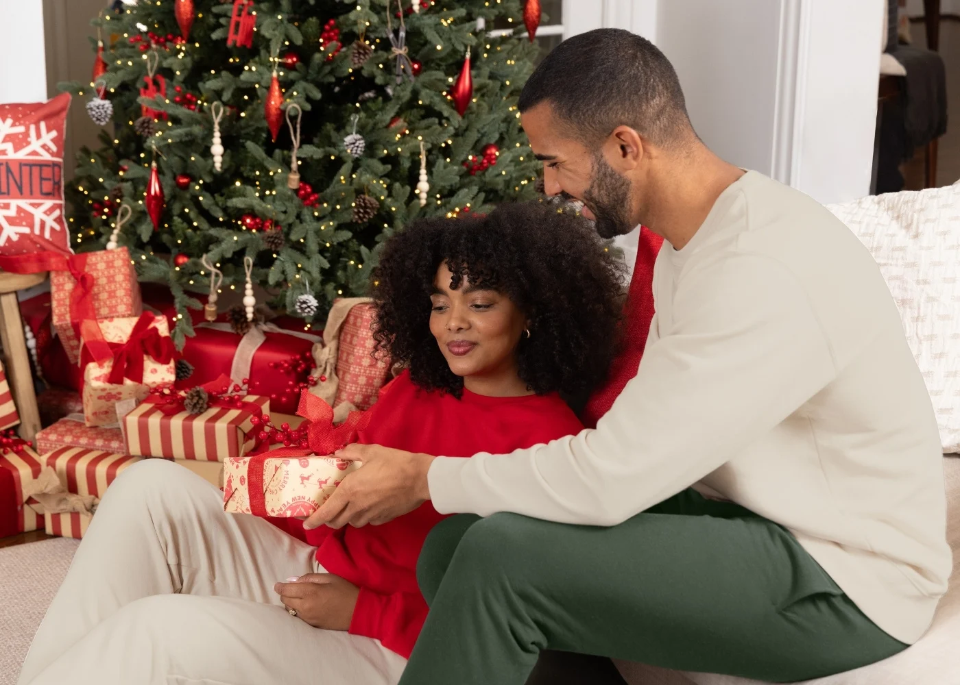Family exchanging gifts. Focus is on Dad giving Mom a gift.