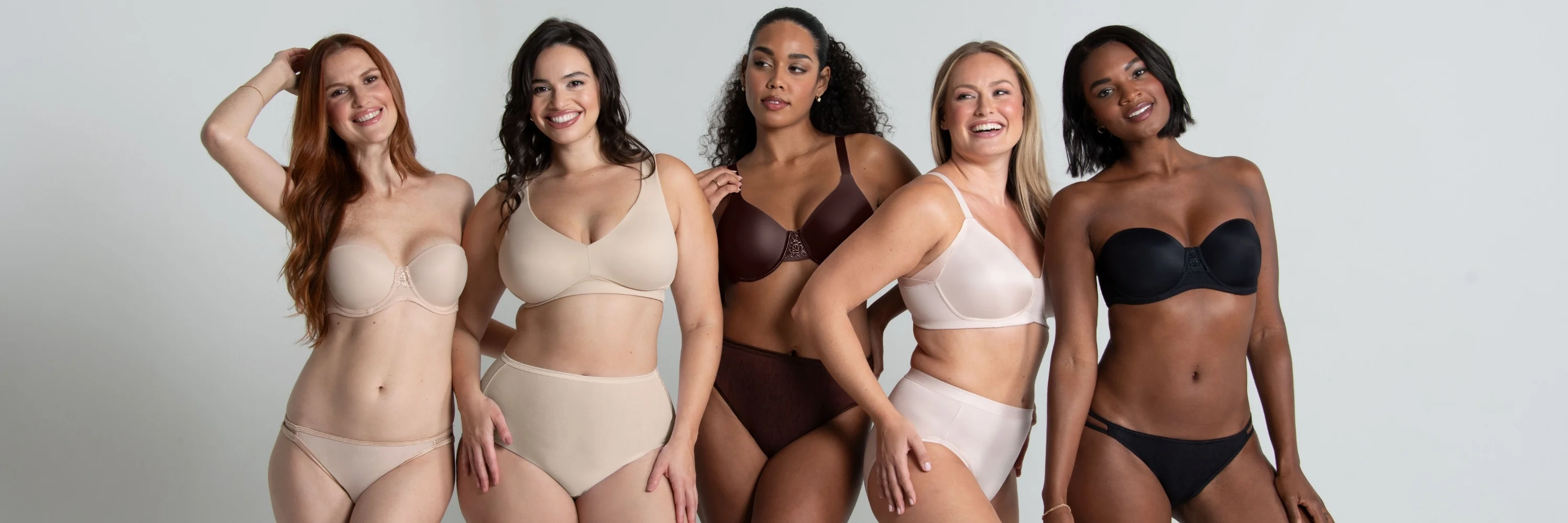5 women in various vanity fair lingerie bra styles ranging from simple sizing, strapless, underwire and wireless posing in a studio..