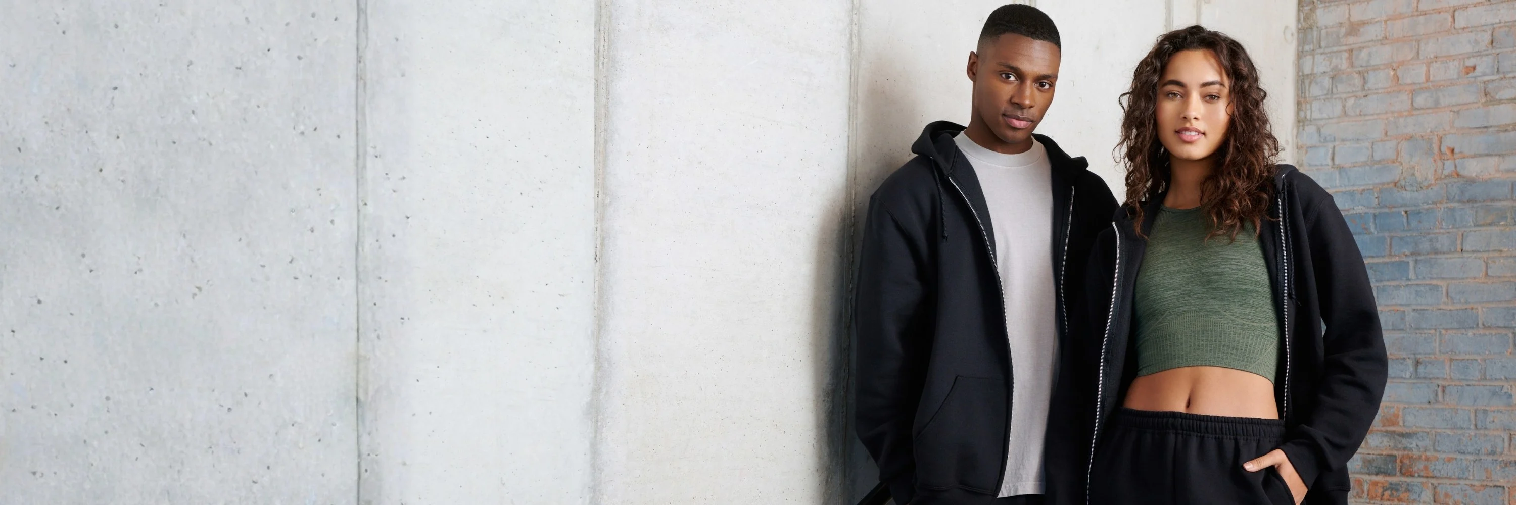 Man and woman wearing russell athletic hoodies and fleece