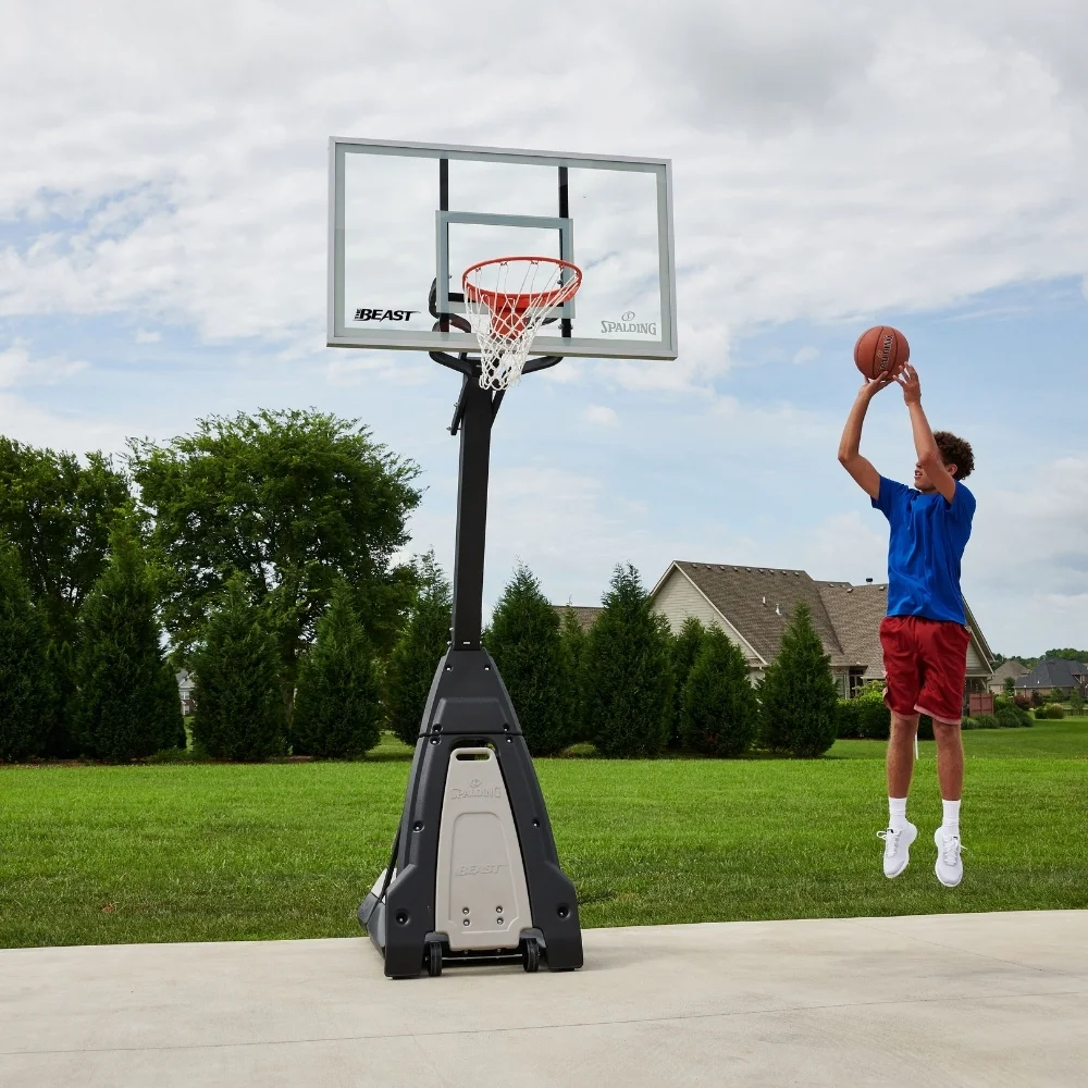 young boy shooting a basket practicing in his driveway at home