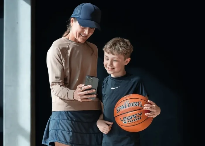 kid holding TF DNA Smart Basketball and woman holding a phone looking at the TF DNA App