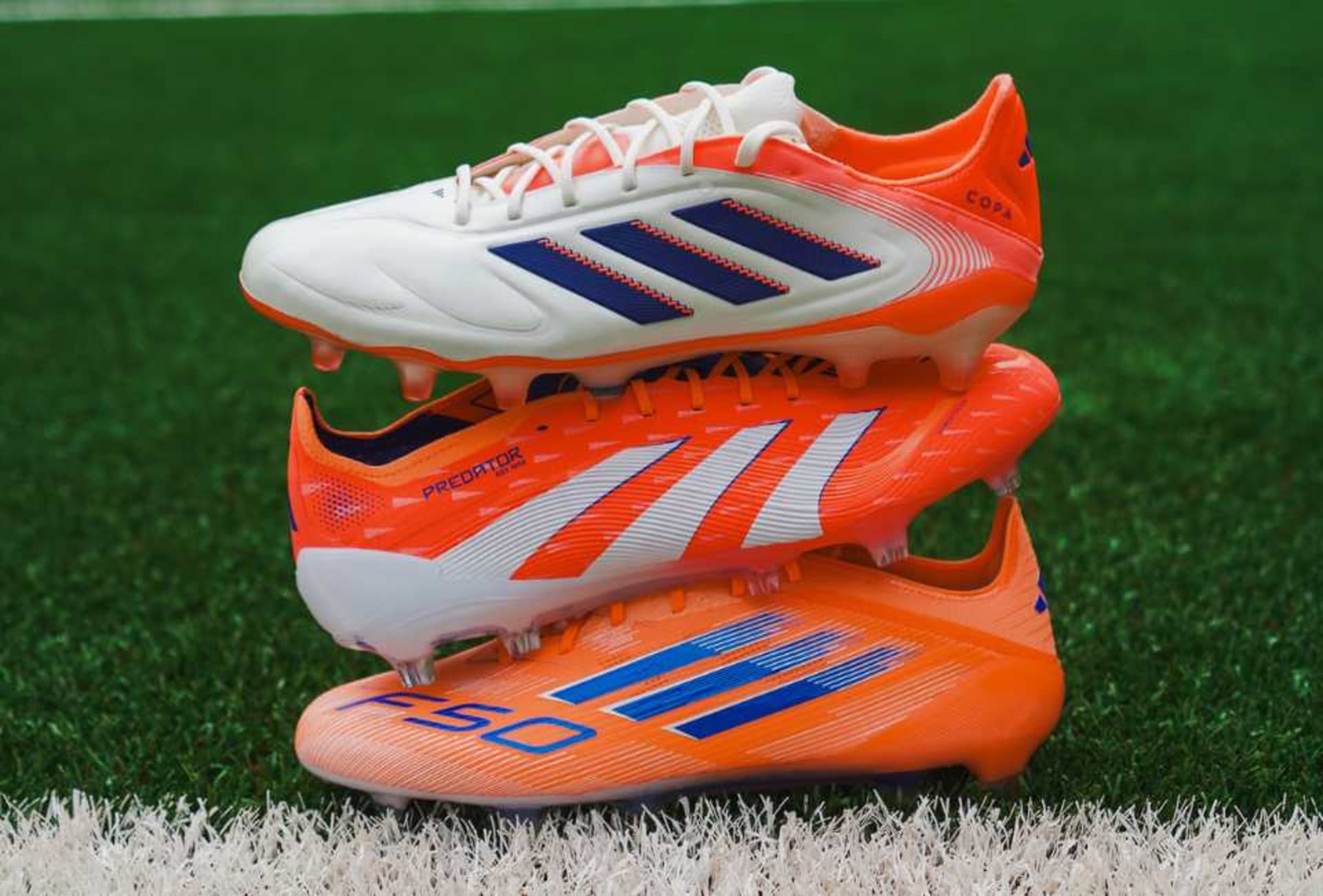 Drei r adidas Coral Blaze Pack Fussballschuhe liegen auf dem Rasen.