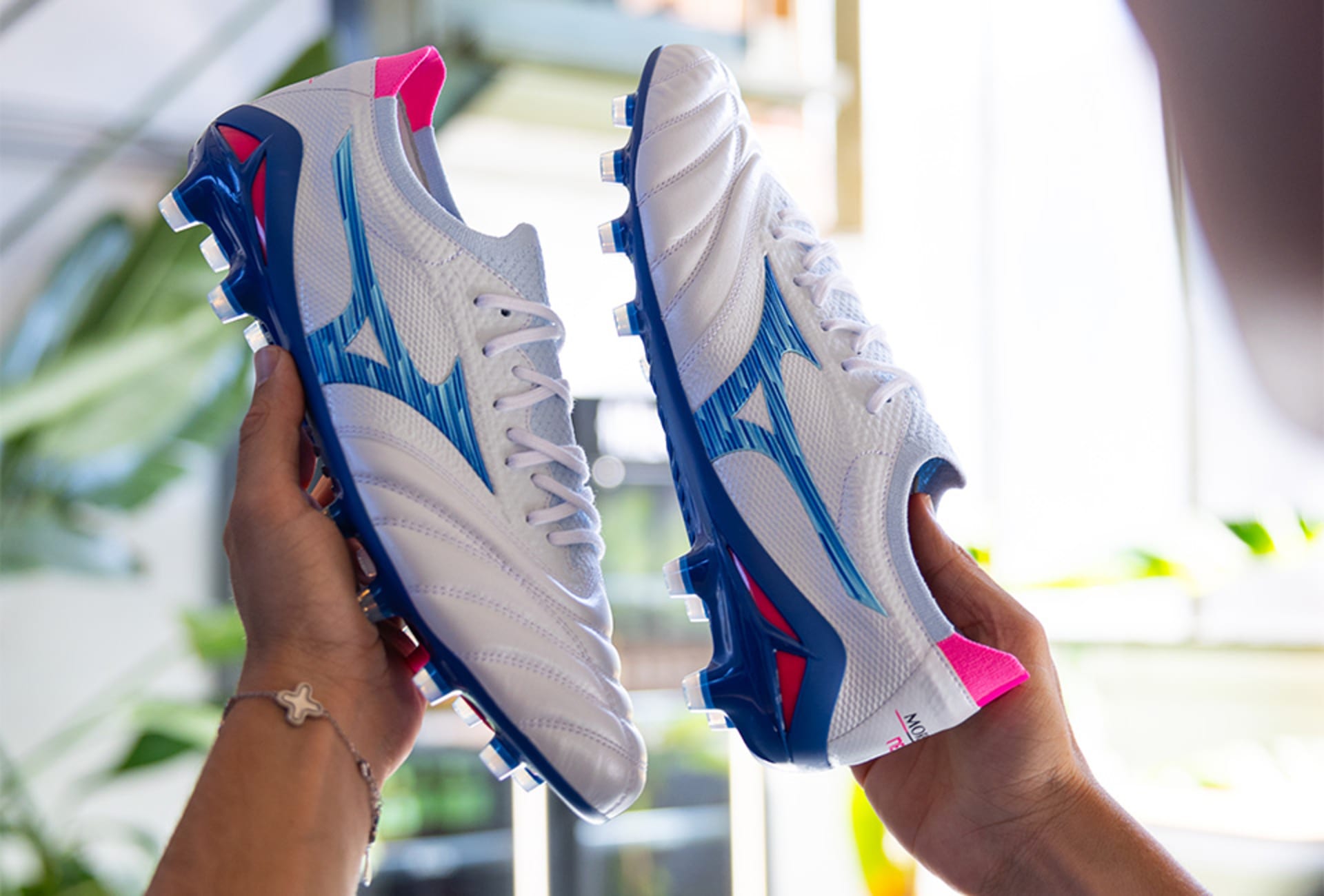 Ein Paar Mizuno Urban Electric Fussballschuhe werden in der Hand gehalten.