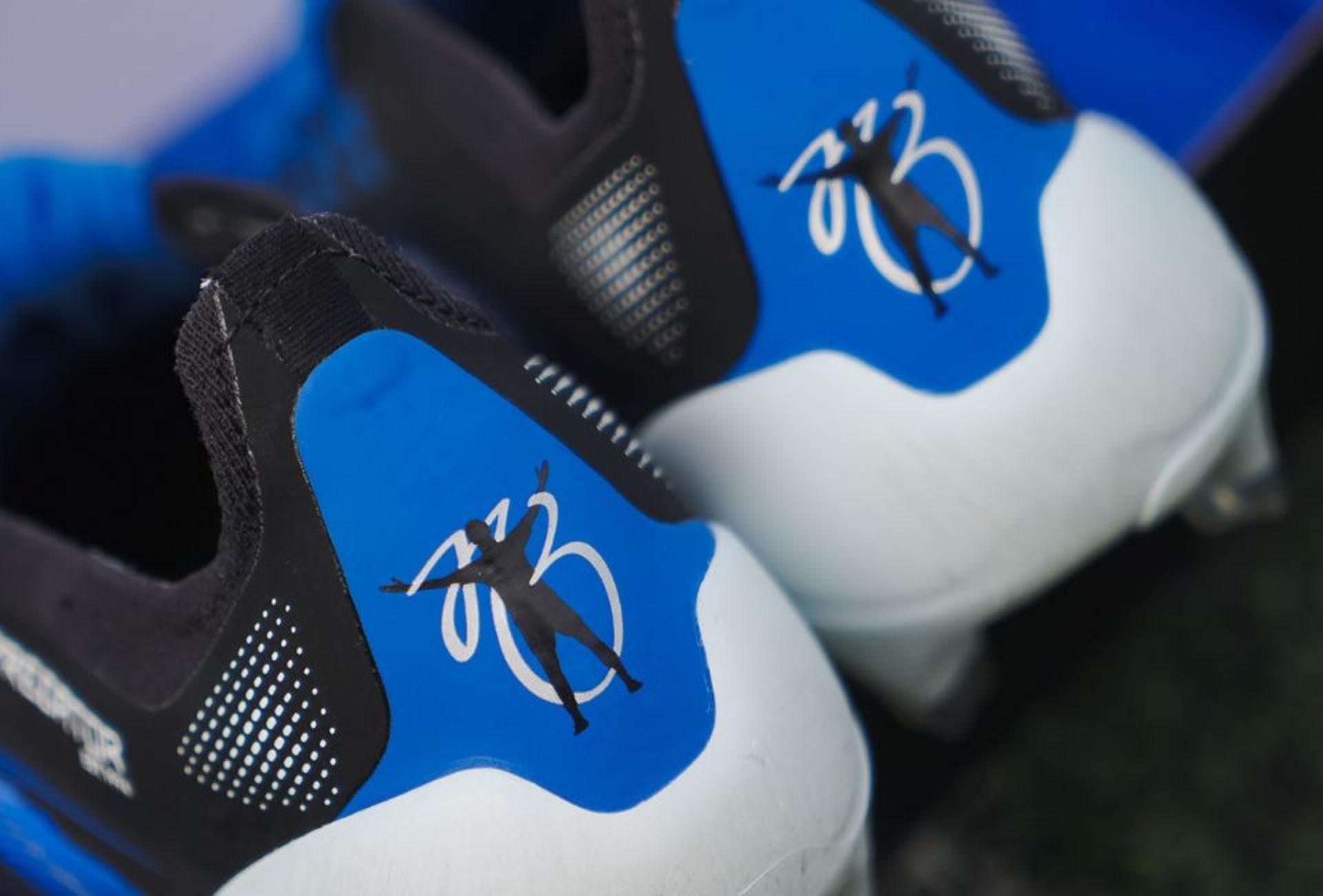 A pair of Radiant Blaze Pack football boots worn on foot.