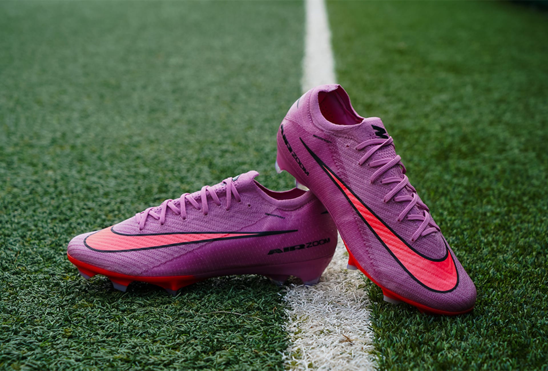 Ein Paar lila Nike Gear Up Fussballschuhe auf Rasen.