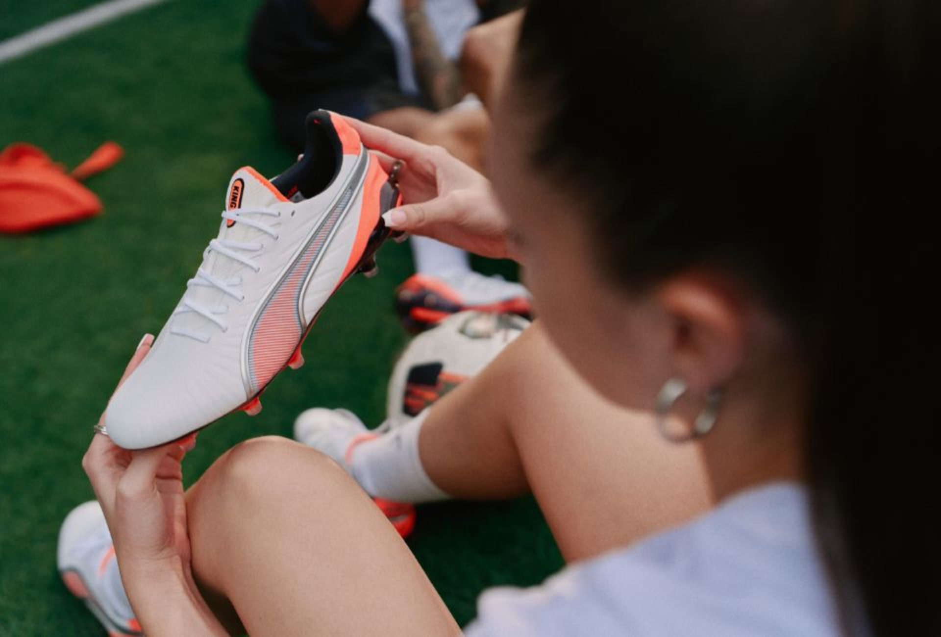 Eine Frau haelt einen Puma Untamed Fussballschuh.