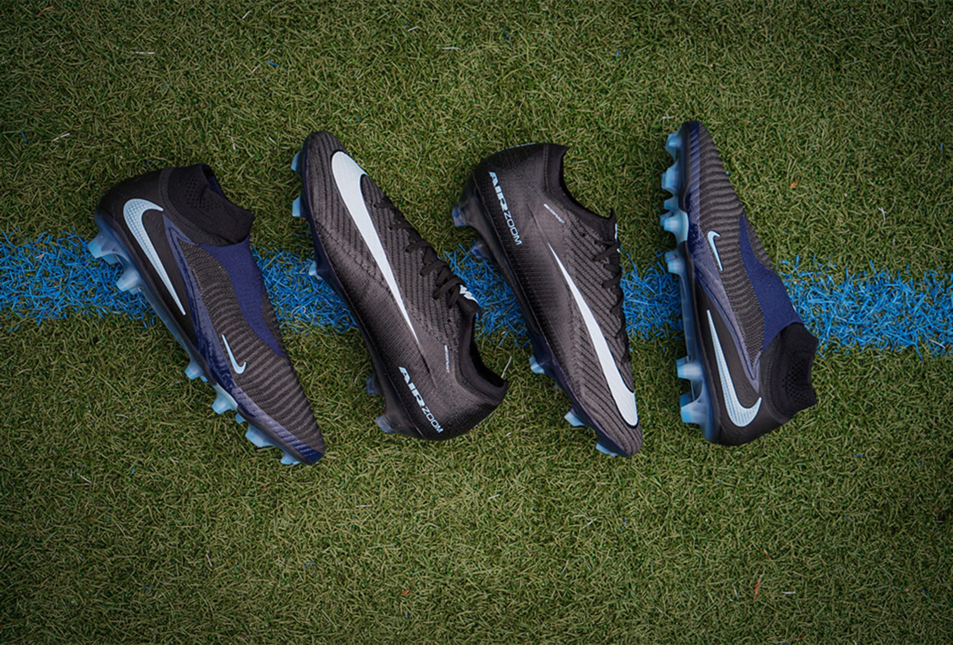 Zwei Paar Nike Shadow Pack Fussballschuhe auf Rasen.