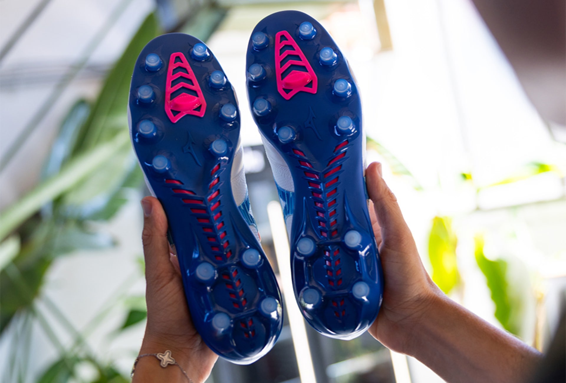 Ein Paar Mizuno Urban Electric Fussballschuhe werden in der Hand gehalten.