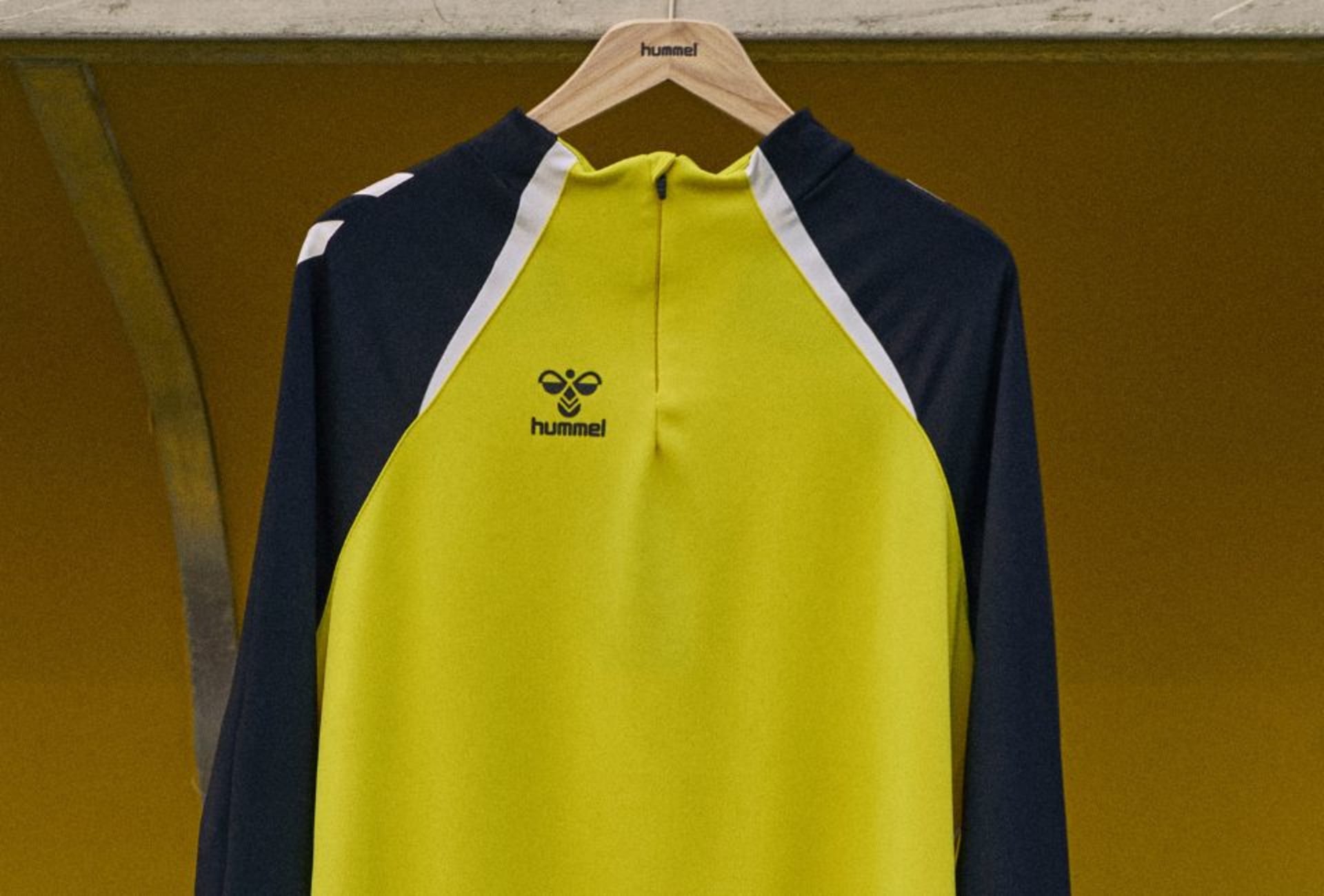 Ein schwarz-gelbes Hummel Trikot hängt auf einem Buegel.