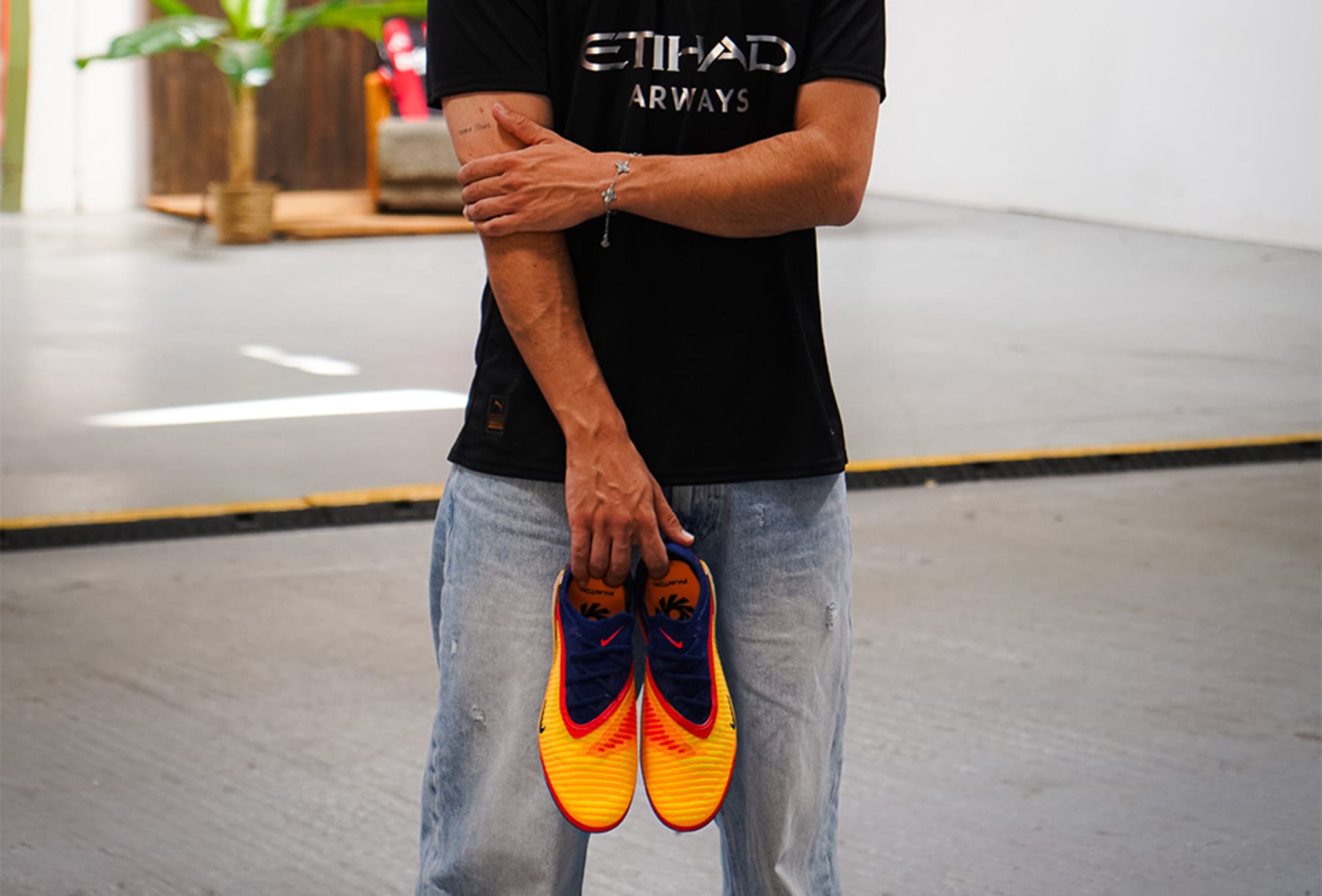 Ein Paar Nike Haaland Phantom 6 Fussballschuhe werden in die Kamera gehalten