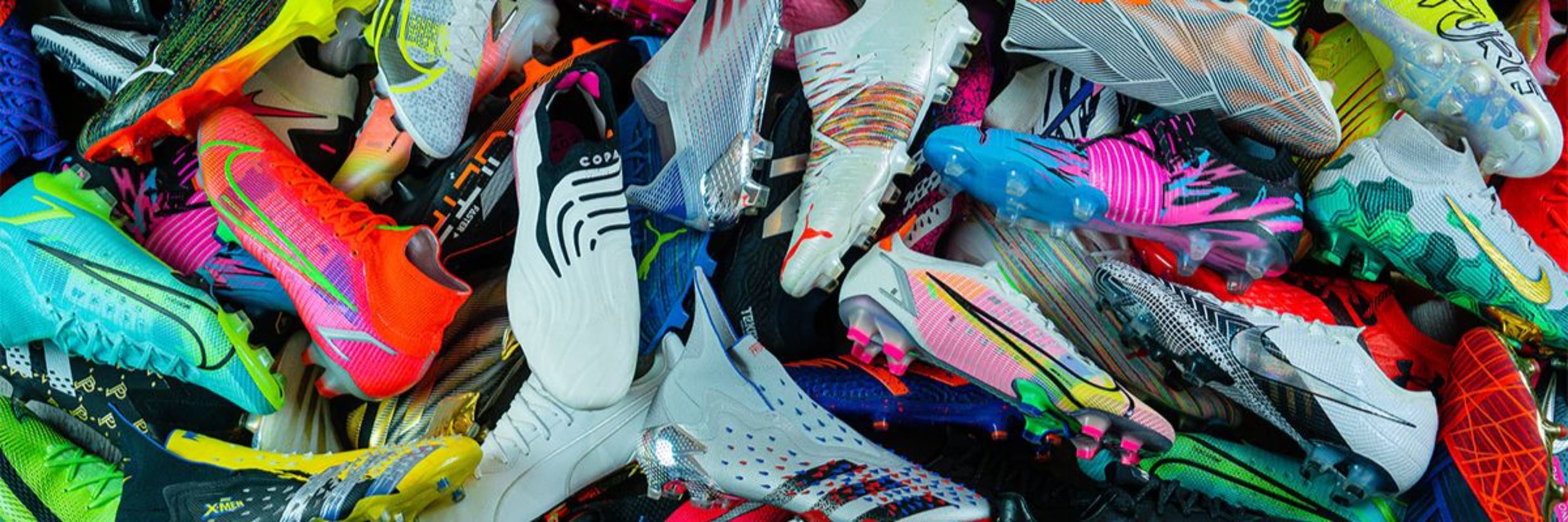 Viele bunte Fussballschuhe liegen auf einem Haufen.