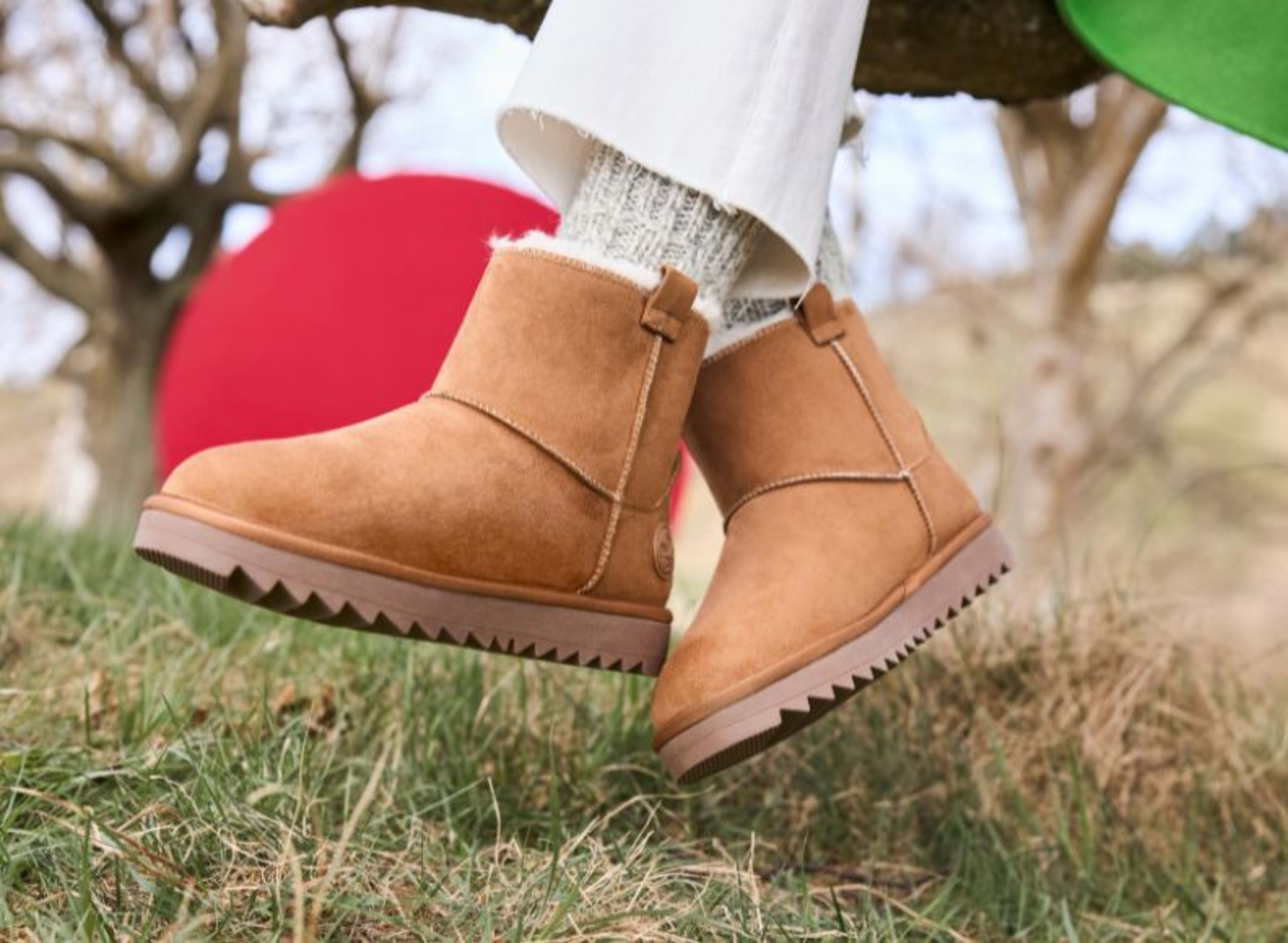 Rieker Damen-Winterboots in Braun mit mit Fell, kombiniert mit kuscheligen beigen Stricksocken und heller Hose.