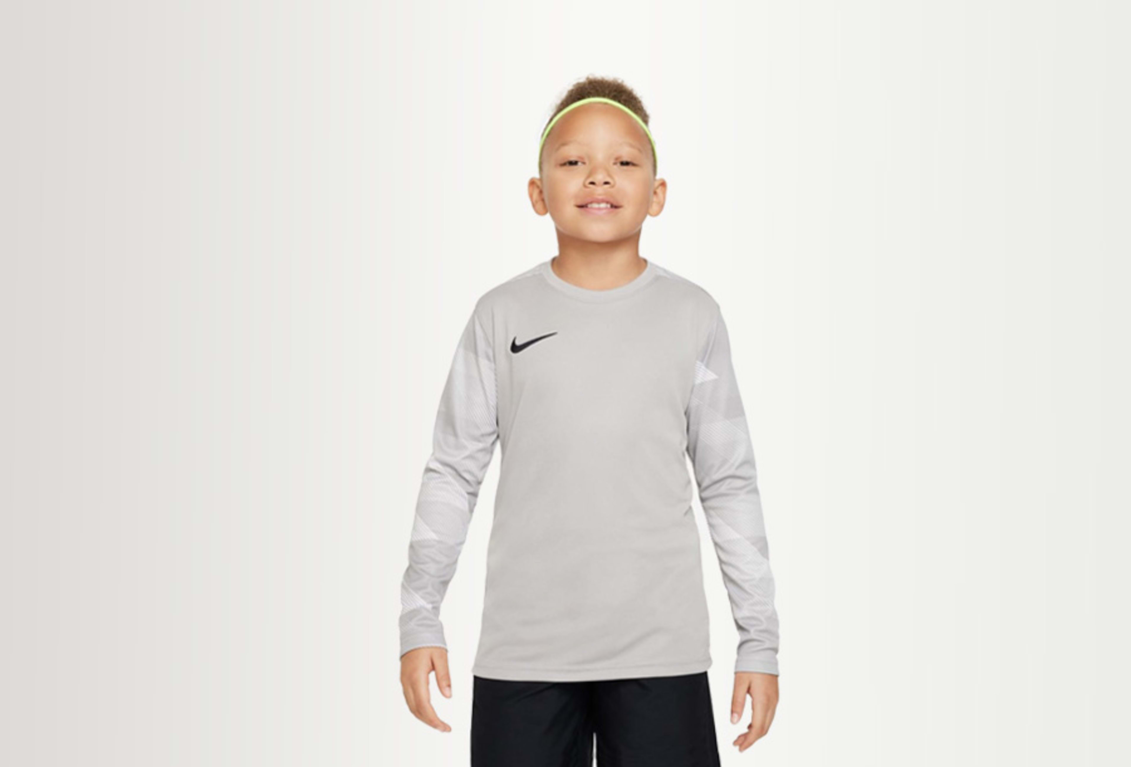 Kind trägt graues Nike Sportoberteil 