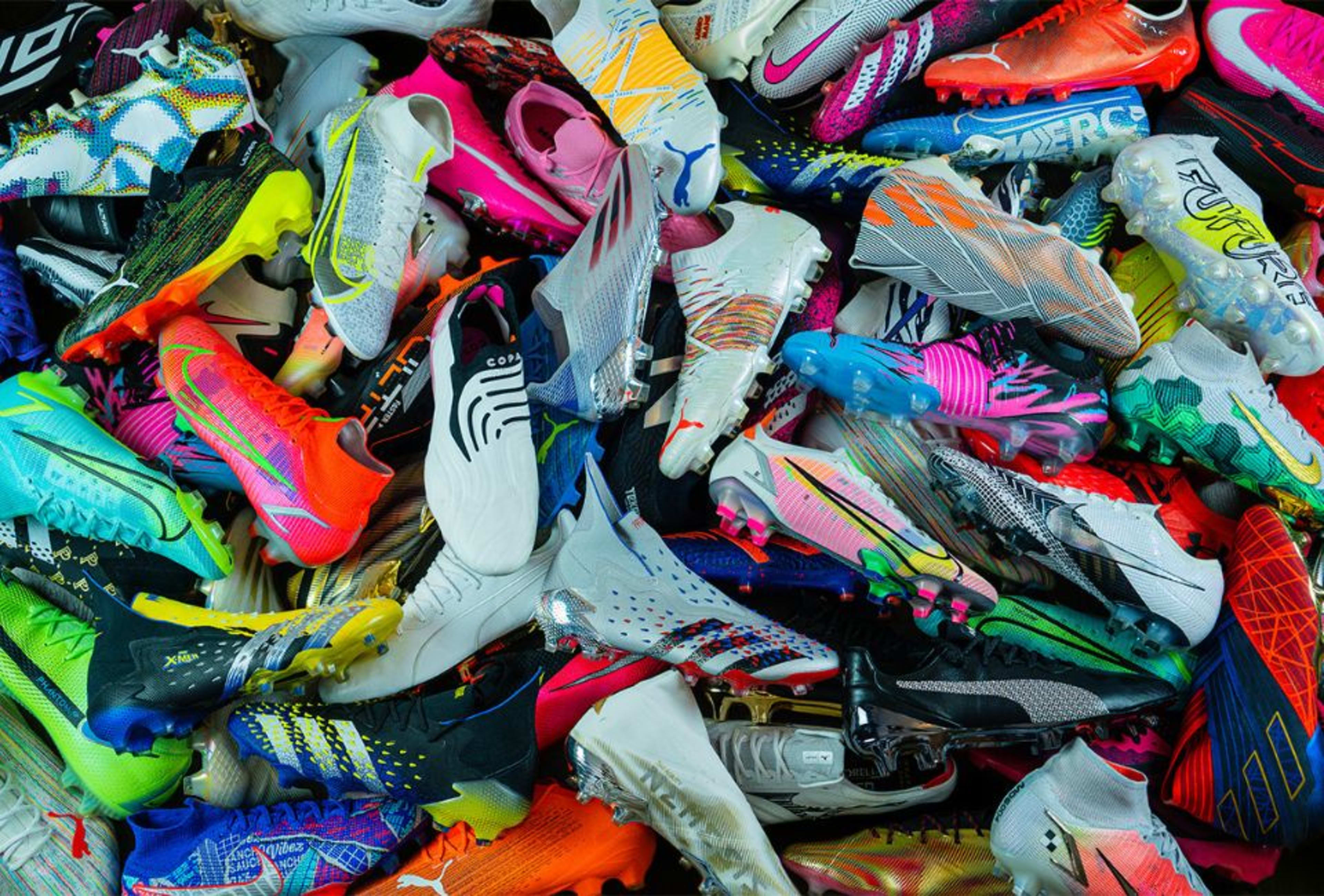 Viele bunte Fussballschuhe liegen auf einem Haufen.