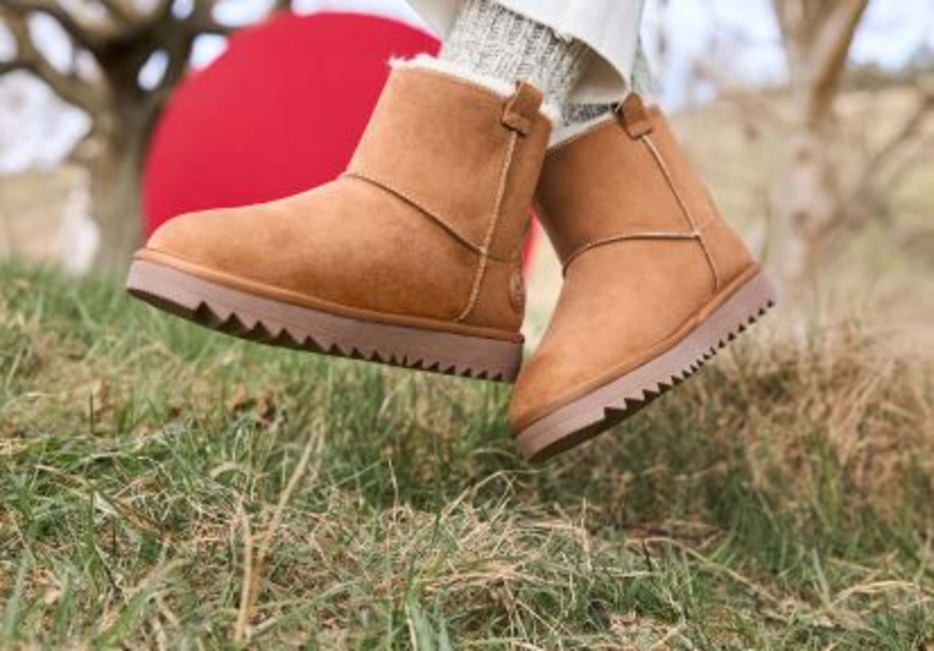 Rieker Damen-Winterboots in Braun mit mit Fell, kombiniert mit kuscheligen beigen Stricksocken und heller Hose.