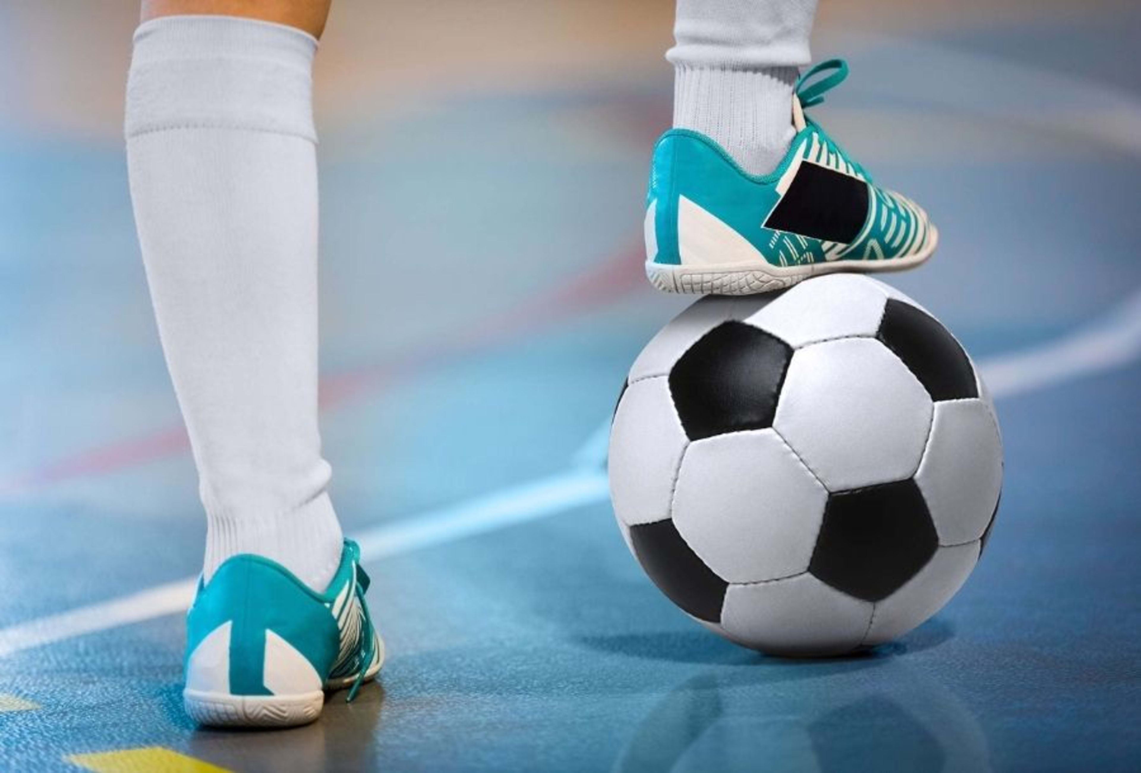 Ein Junge stoppt einen Ball mit dem Fuss.