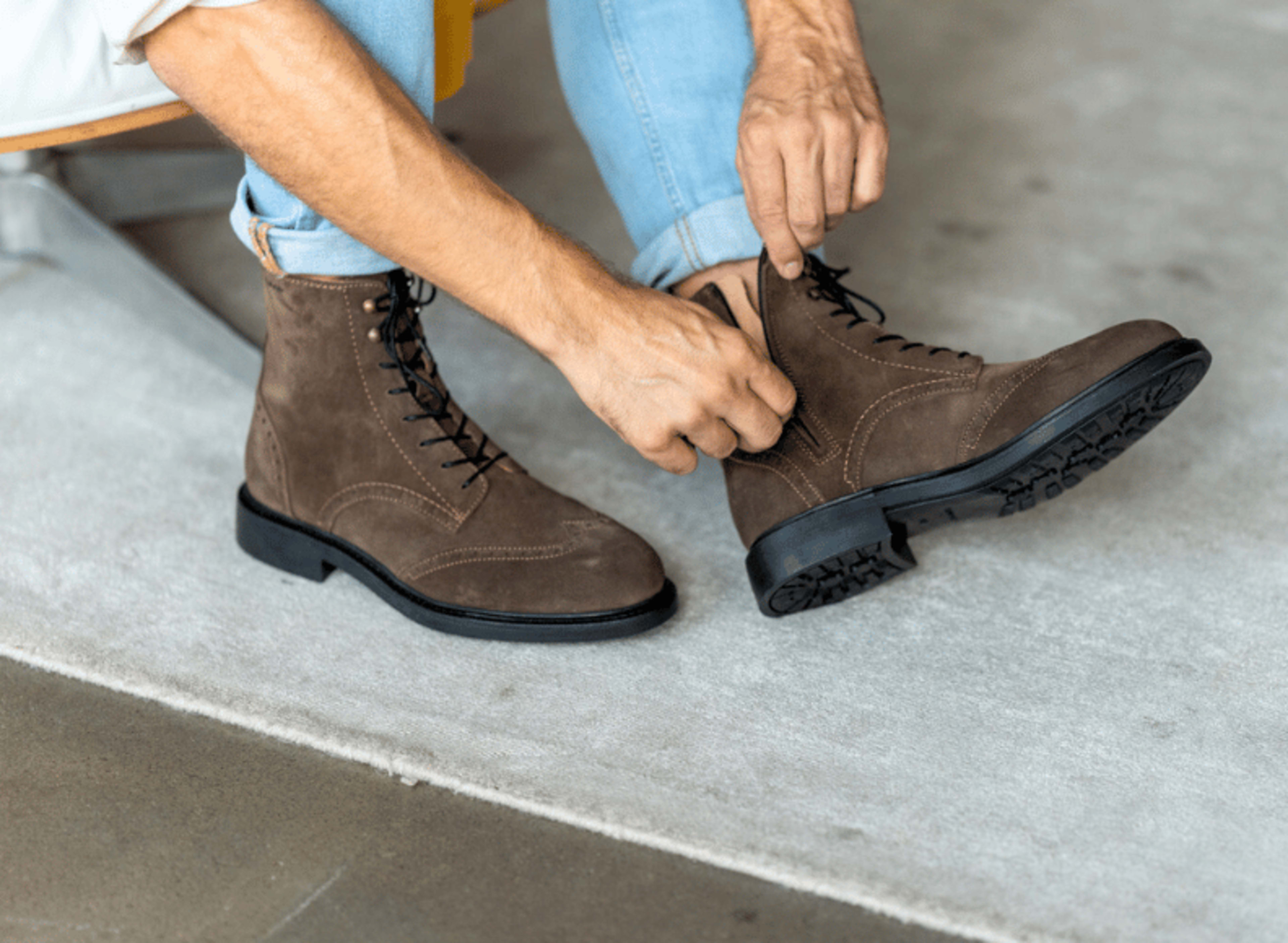 Mann traegt braune Budapest-Schnuerstiefeletten am Fuss.