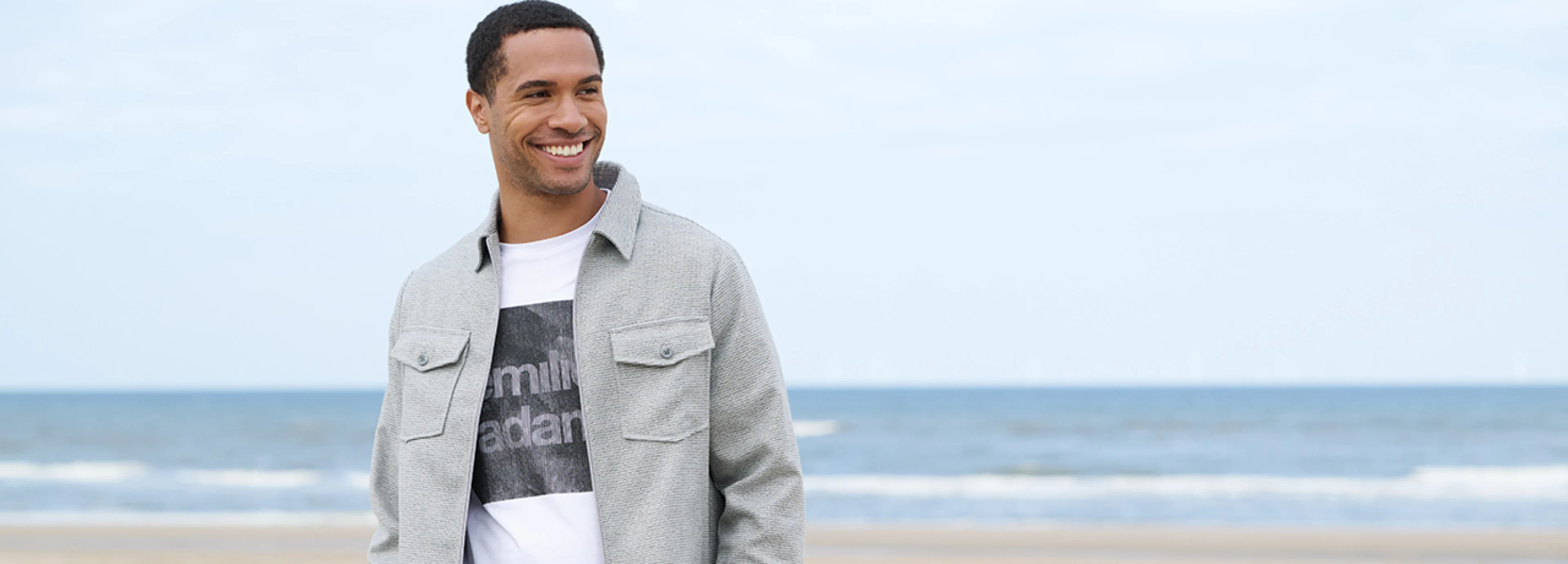 Stylische Jacke für Herren in hellgrau, kombiniert mit einem weißen Basic T-Shirt und einer Chino..