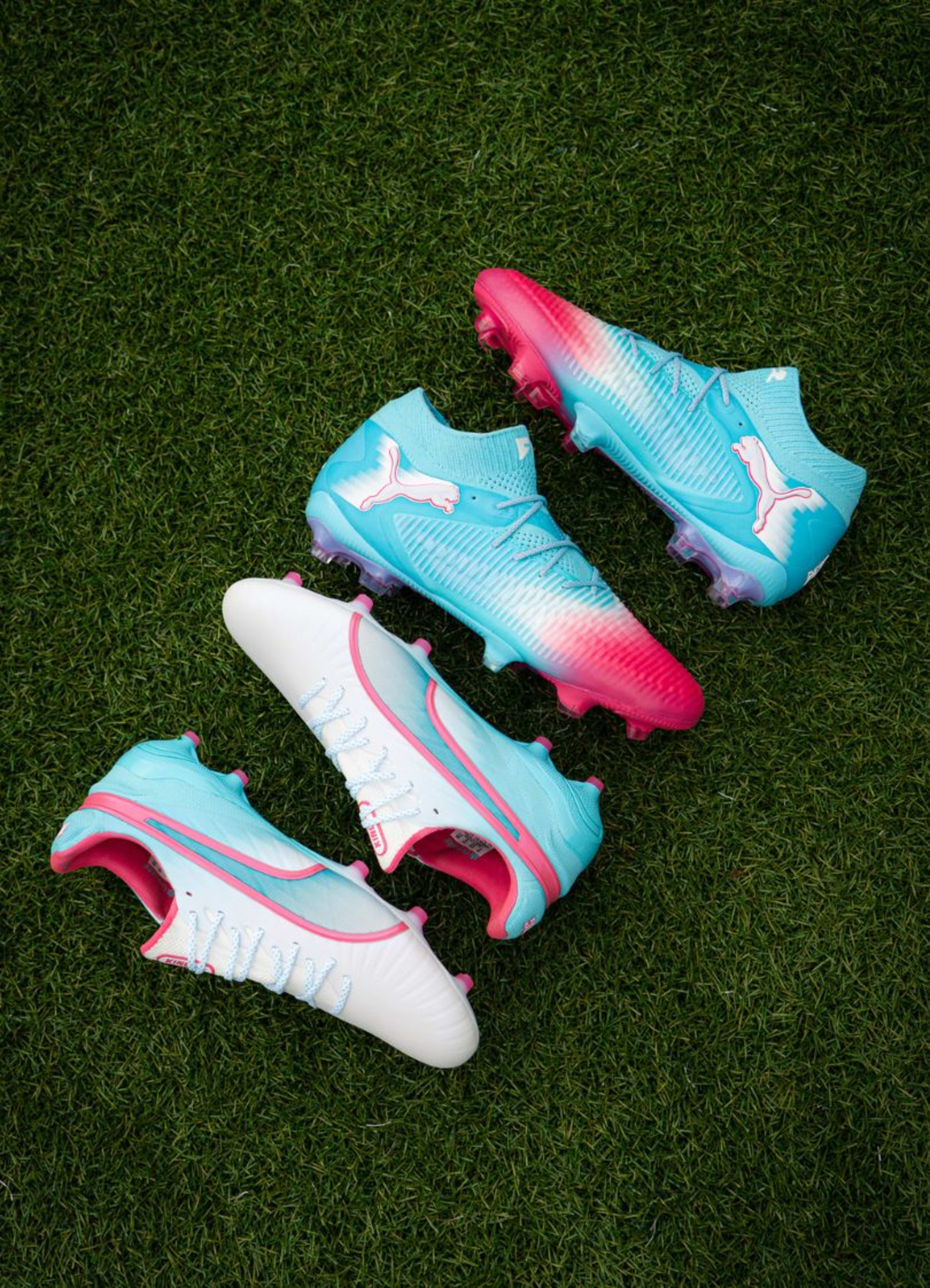 Zwei Paar Puma Re-Charge Fussballschuhe liegen nebeneinander auf dem Rasenplatz.