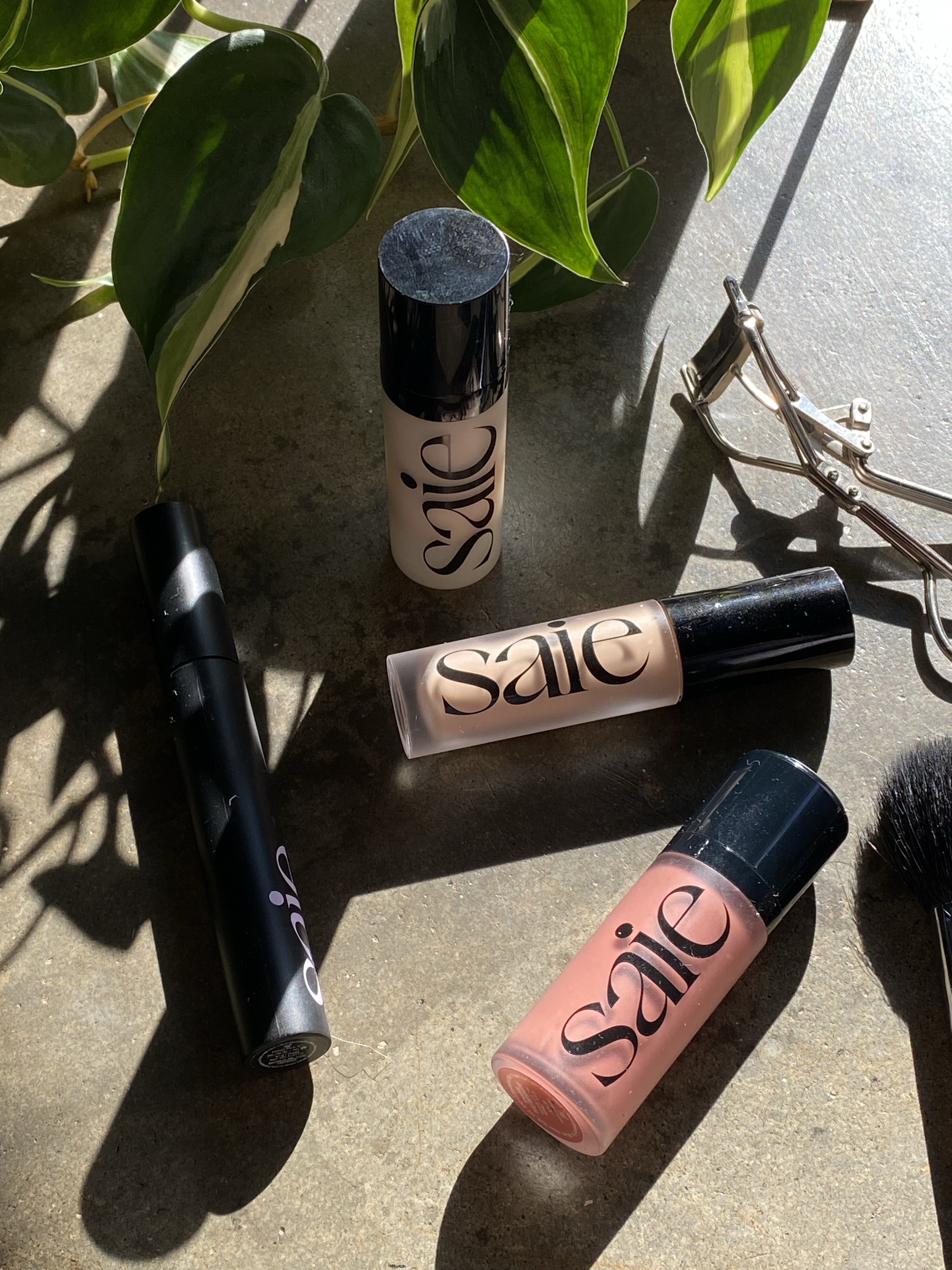 Beauty products styled on a textured bed