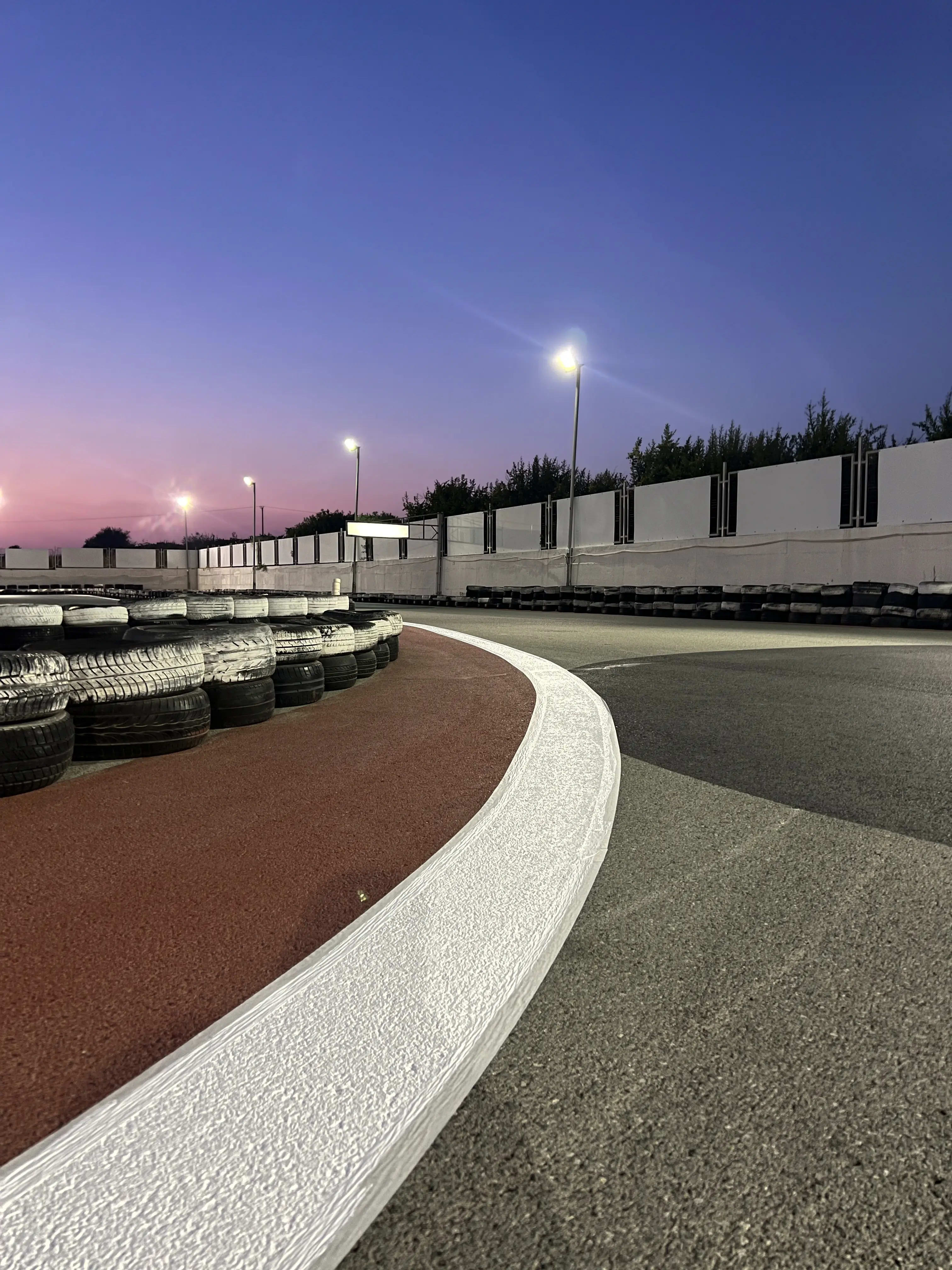Kart track at evening after fresh repaint with mountains in background