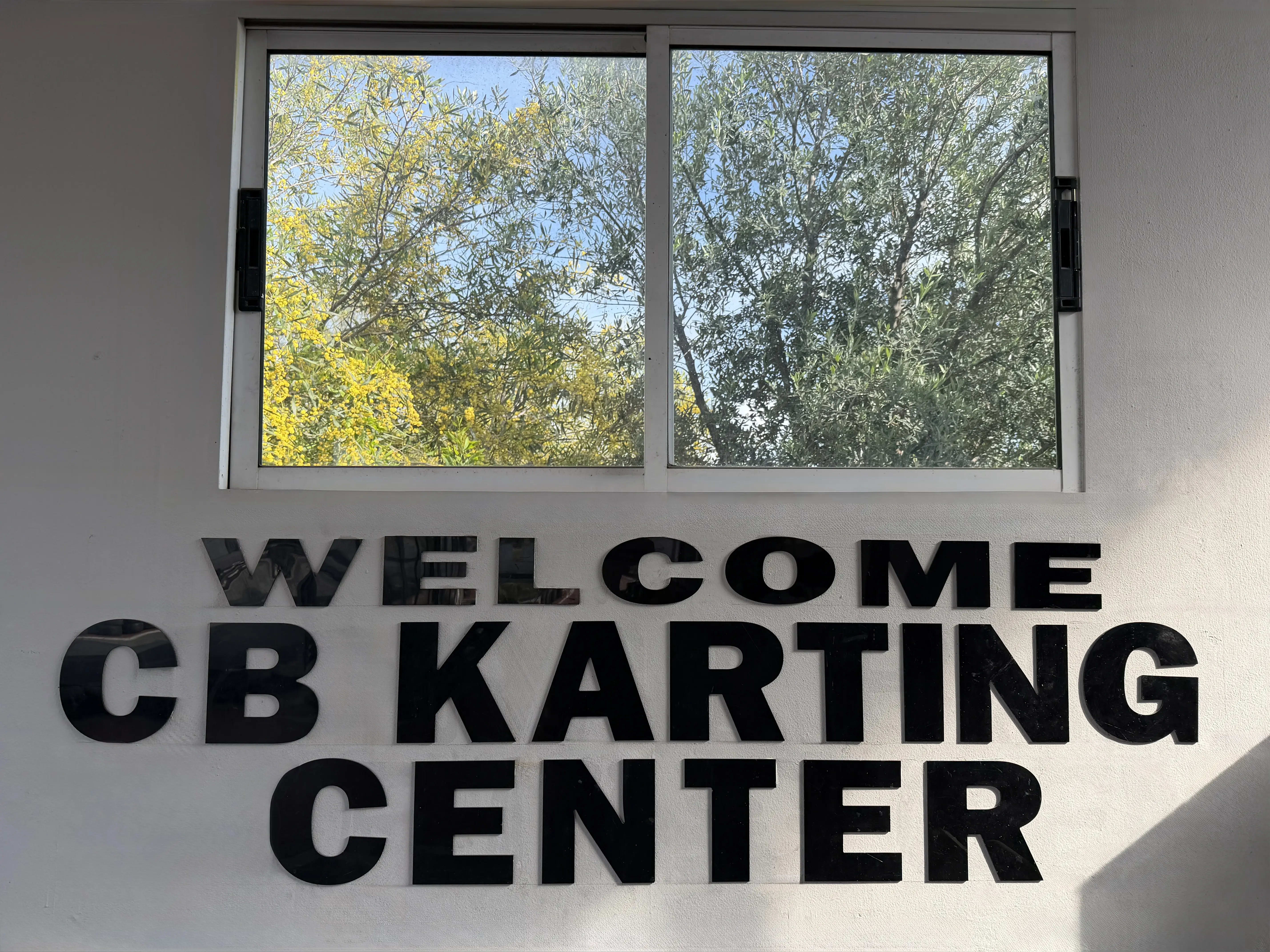 CB-Karting logo with black lettering on a white wall
