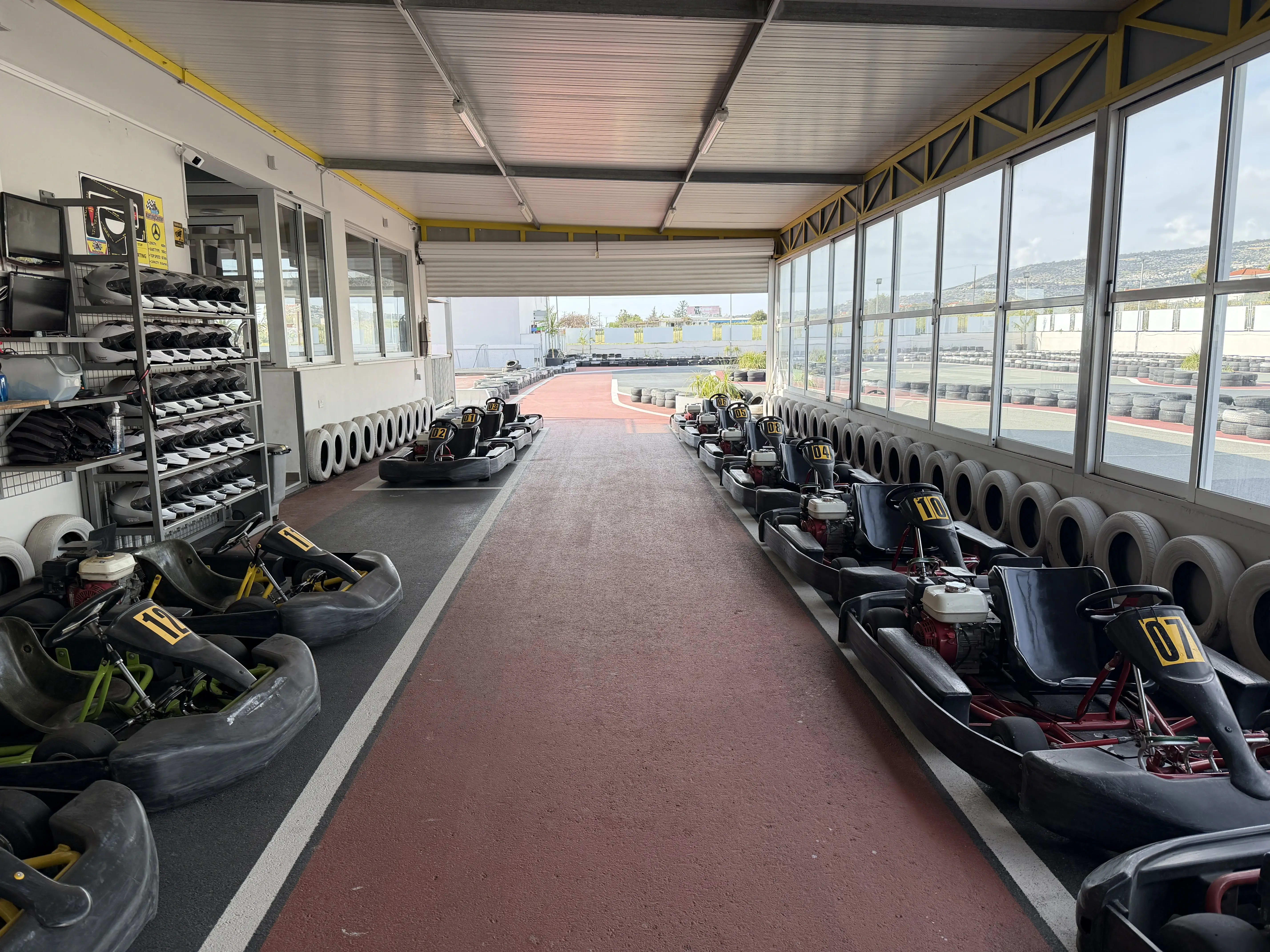 Pit stop interior with karts and track visible through windows