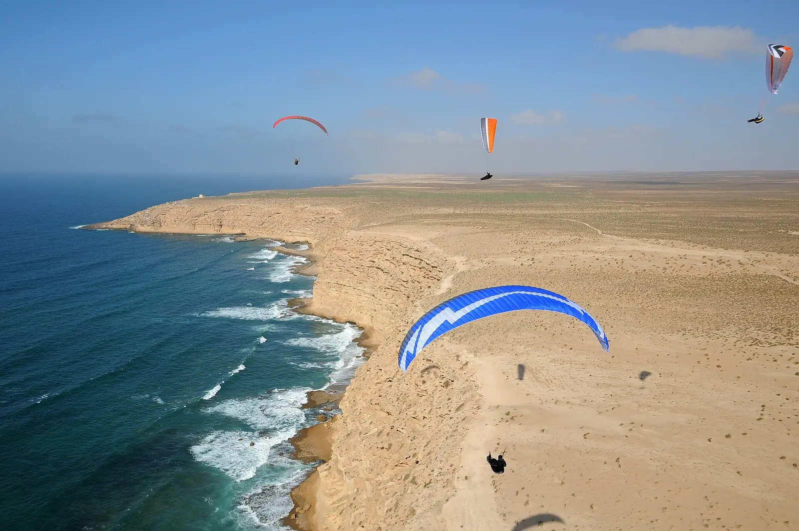 Gleitschirmflieger über einem Sandstrand an der Atlantikküste Marokkos