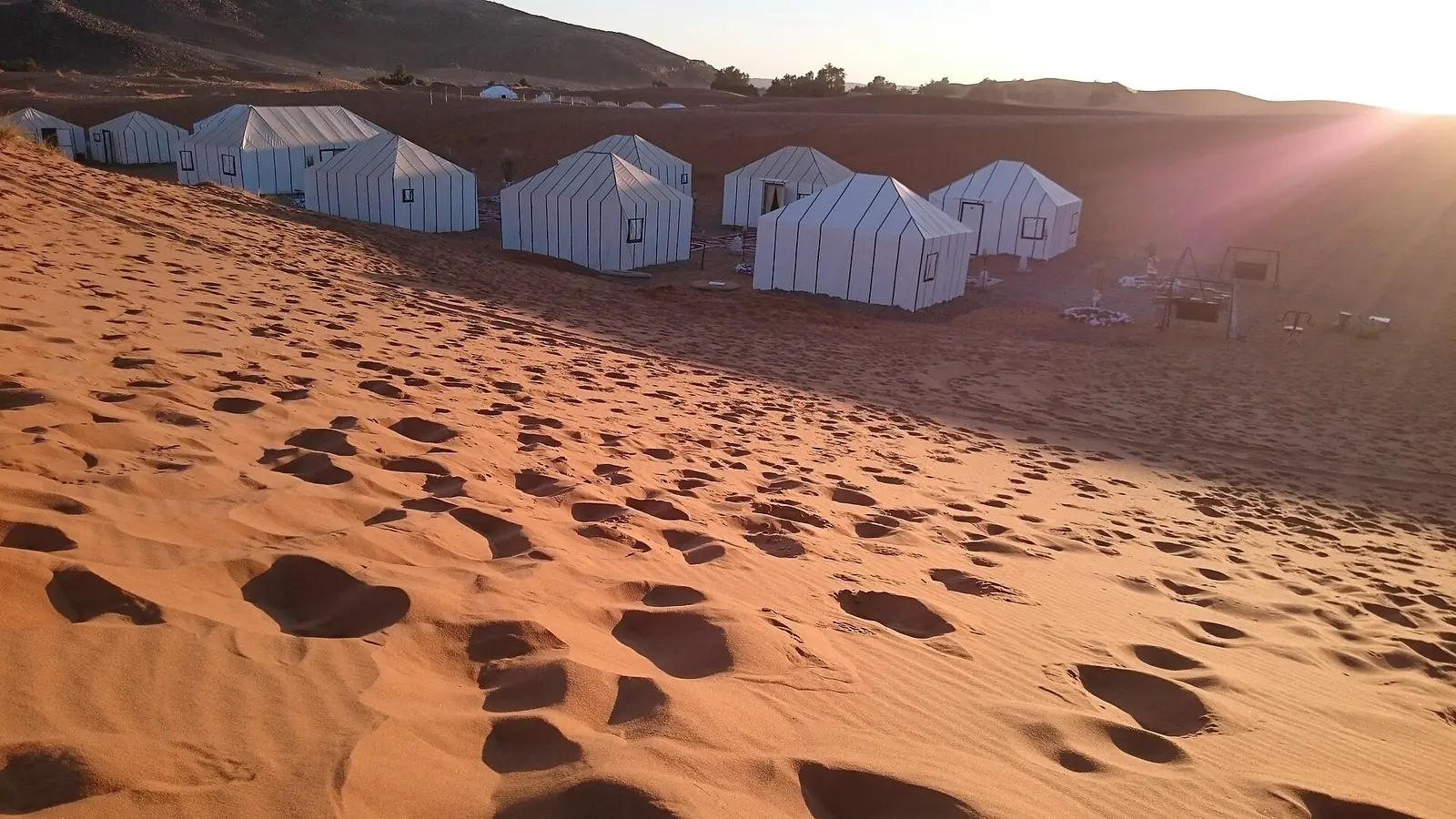 White tents of a desert camp among the dunes of Merzouga